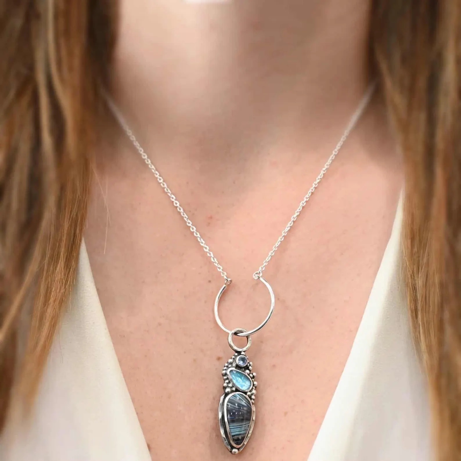 Claire Charm Necklace shown on model with white shirt and brown hair