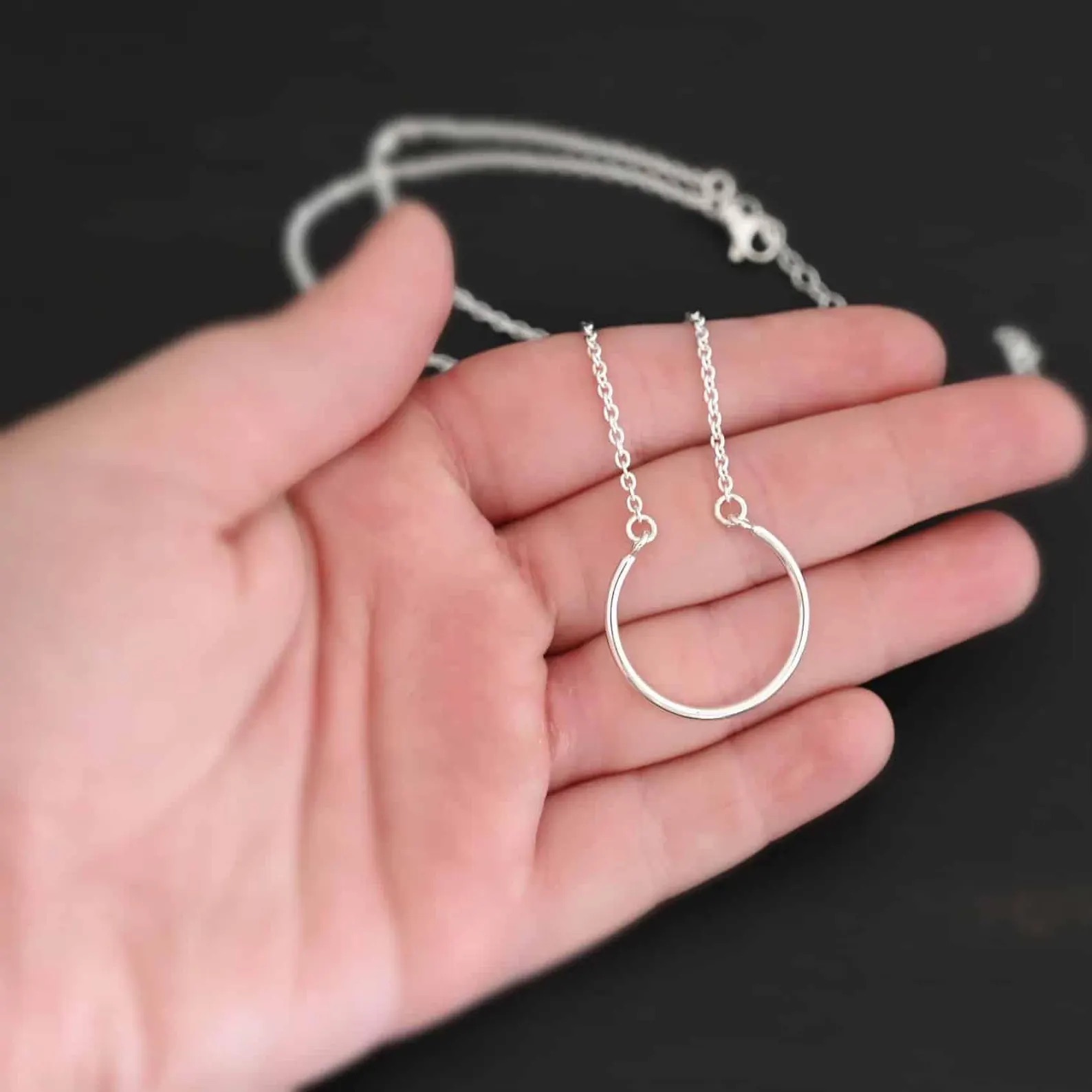 Claire Charm Necklace shown in hand