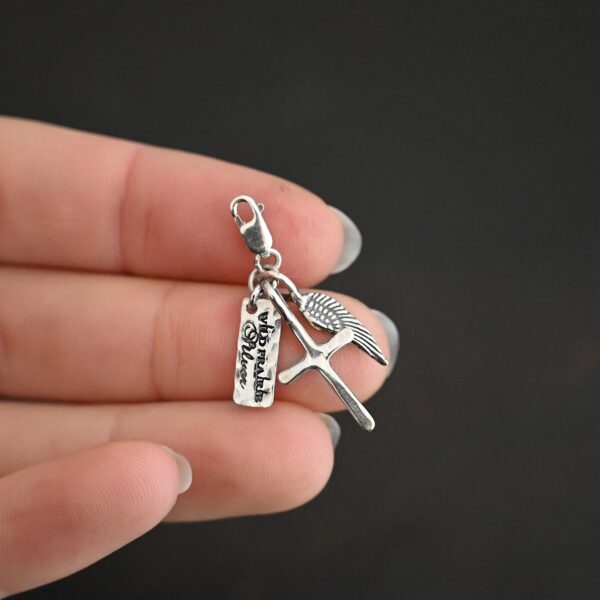Wild Prairie Charm - shiny shown in hand - wild prairie tag, cross & angel wing charm