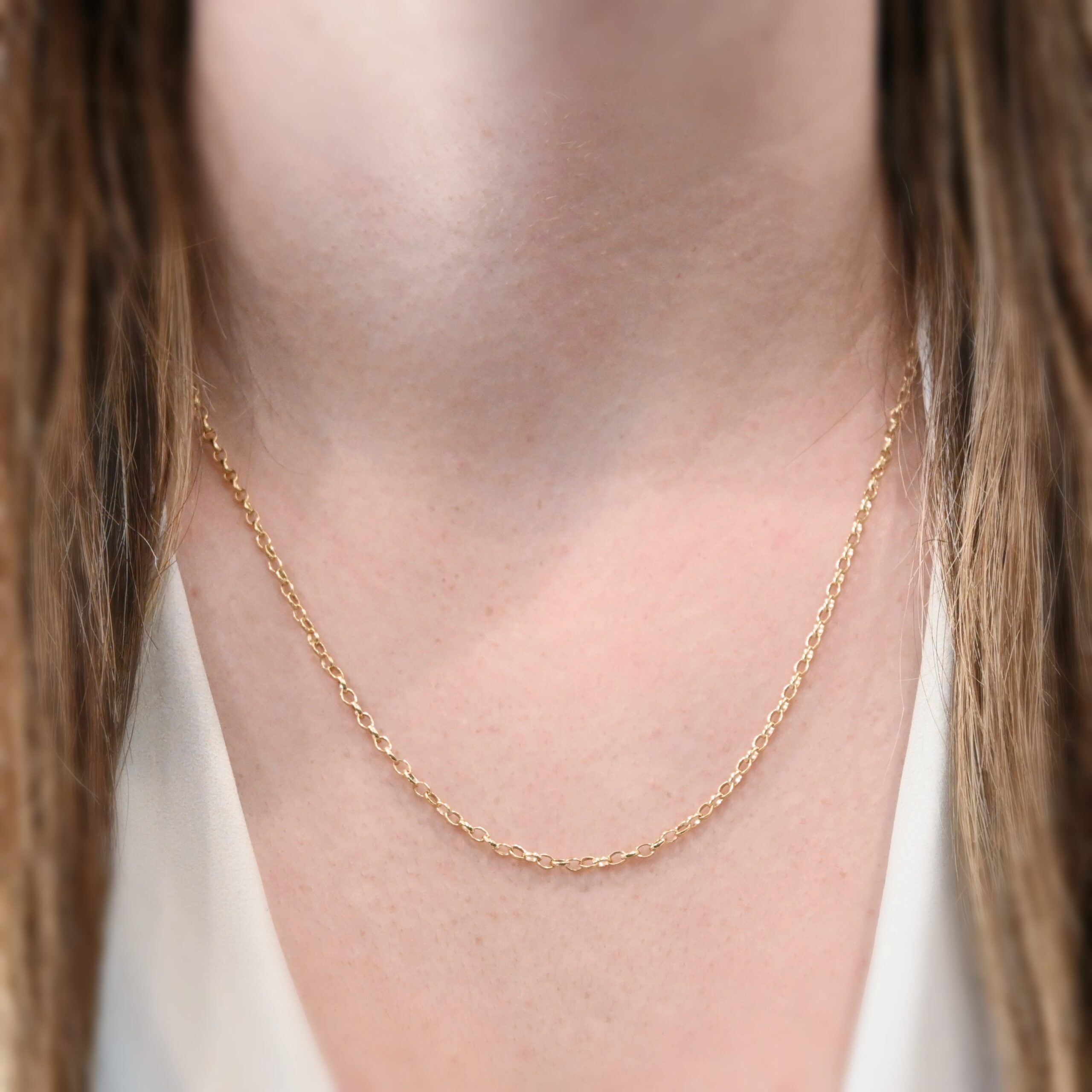 14k gold filled Ruby Rolo Chain - 20-22" shown on model with white shirt and brown hair