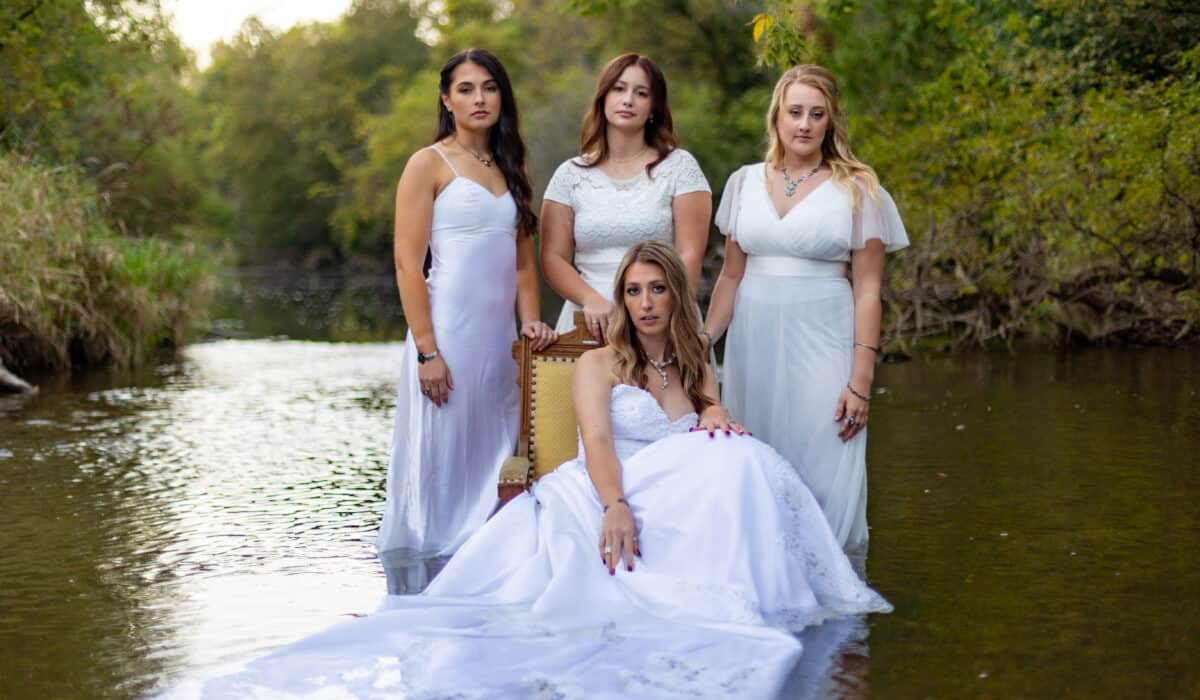Ashlyn, Savannah, Bekah, & Skyla in wedding dresses modeling in the river with jewelry