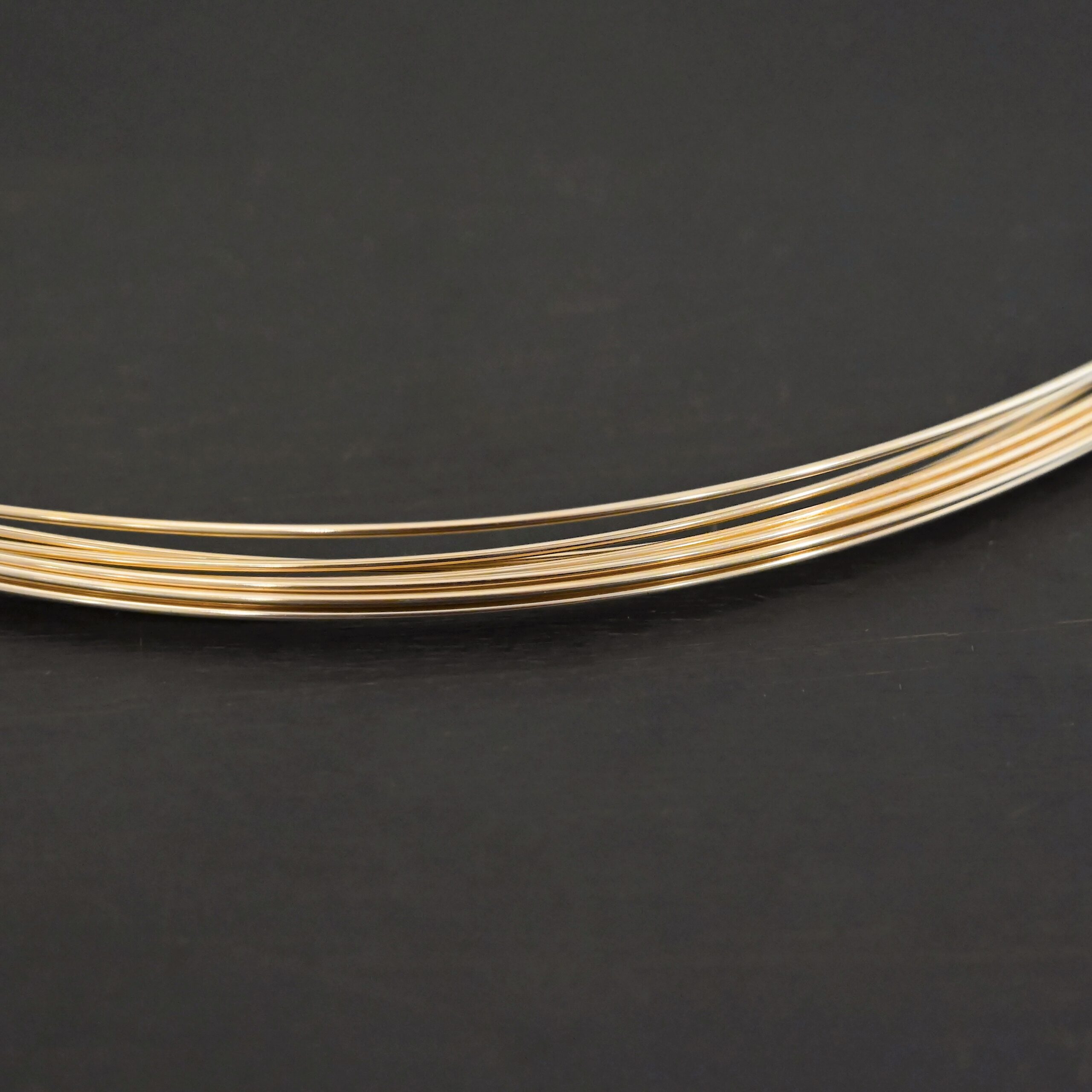 Gold Filled Round Wire shown on dark background