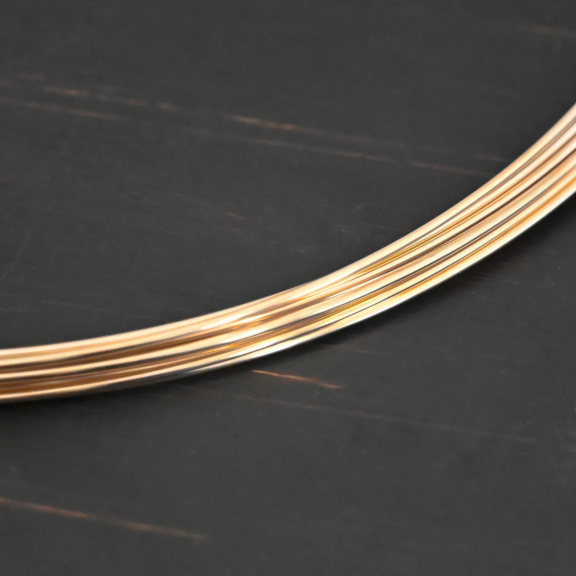 Gold Filled Round Wire shown on dark background