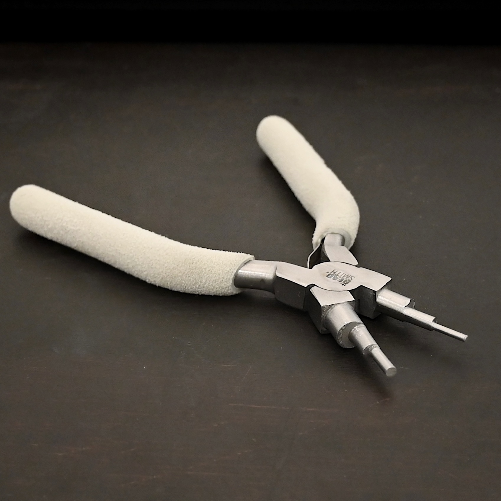 Double Stepped Mandrel included in kit - stainless steel and white foam handle shown on dark background