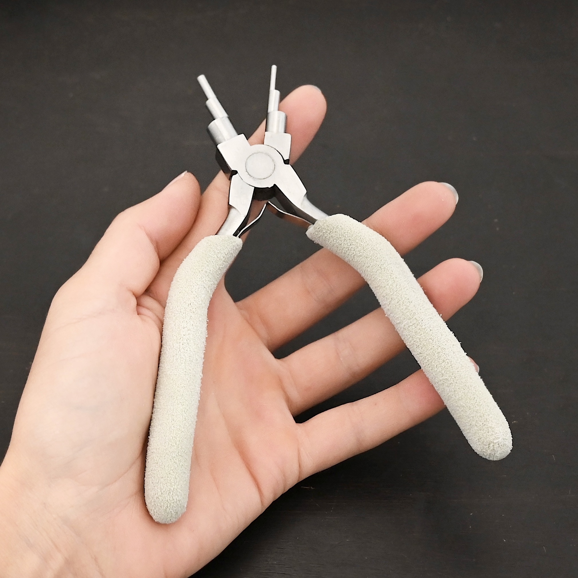 Double Stepped Mandrel included in kit - stainless steel and white foam handle shown in hand