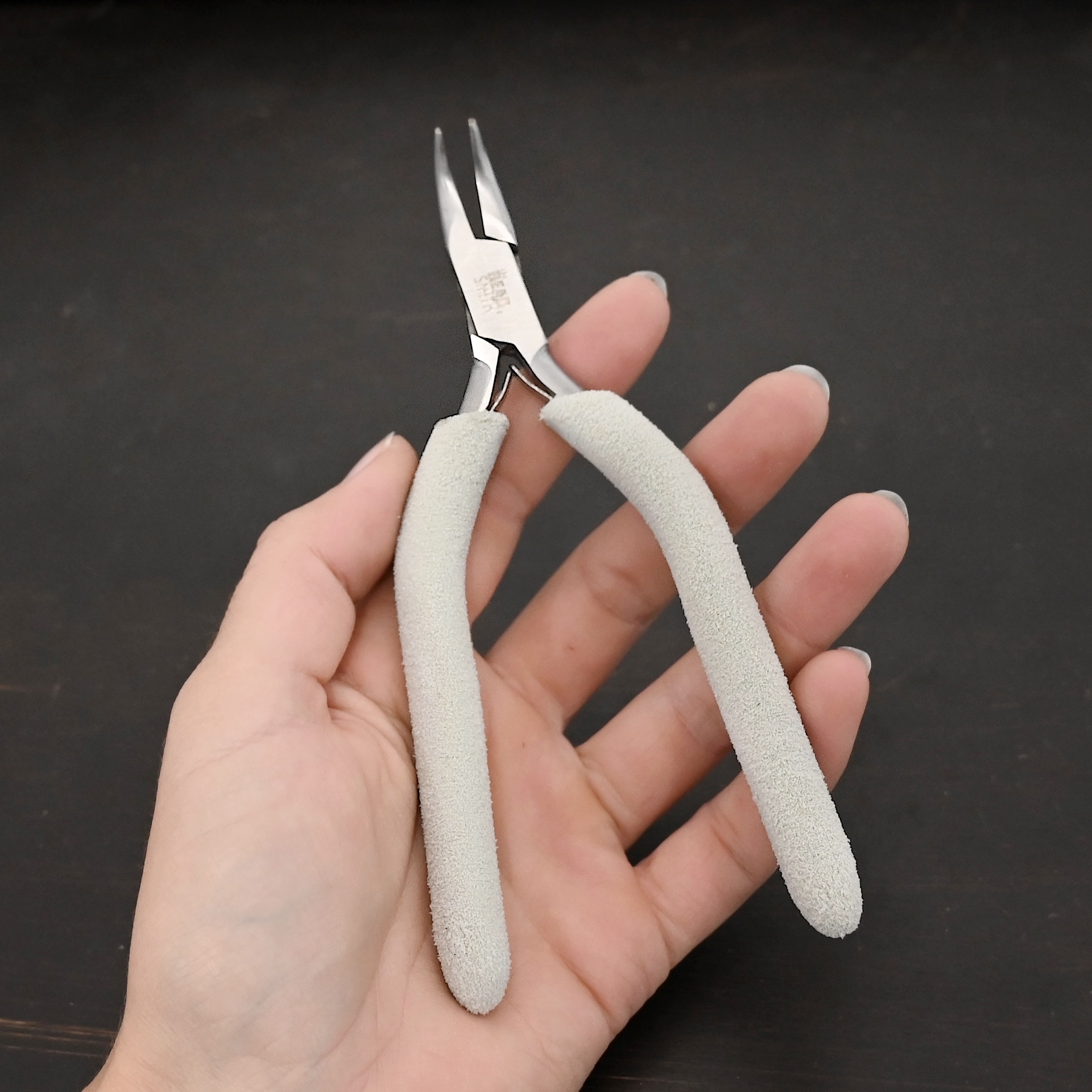Curved Pliers included in kit - stainless steel and white foam handle shown in hand