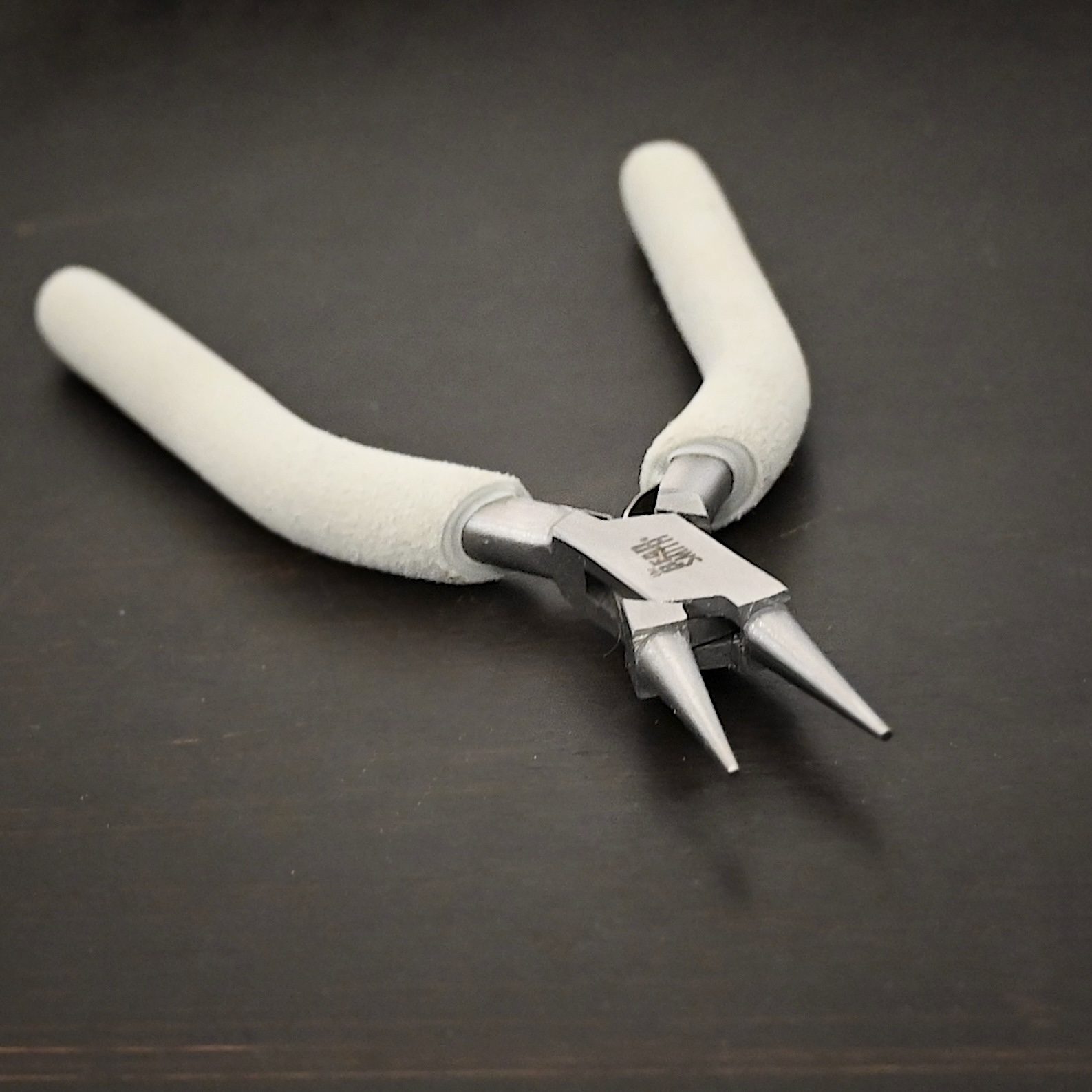 Double Wire Wrapping Pliers included in kit - stainless steel and white foam handle shown on dark background