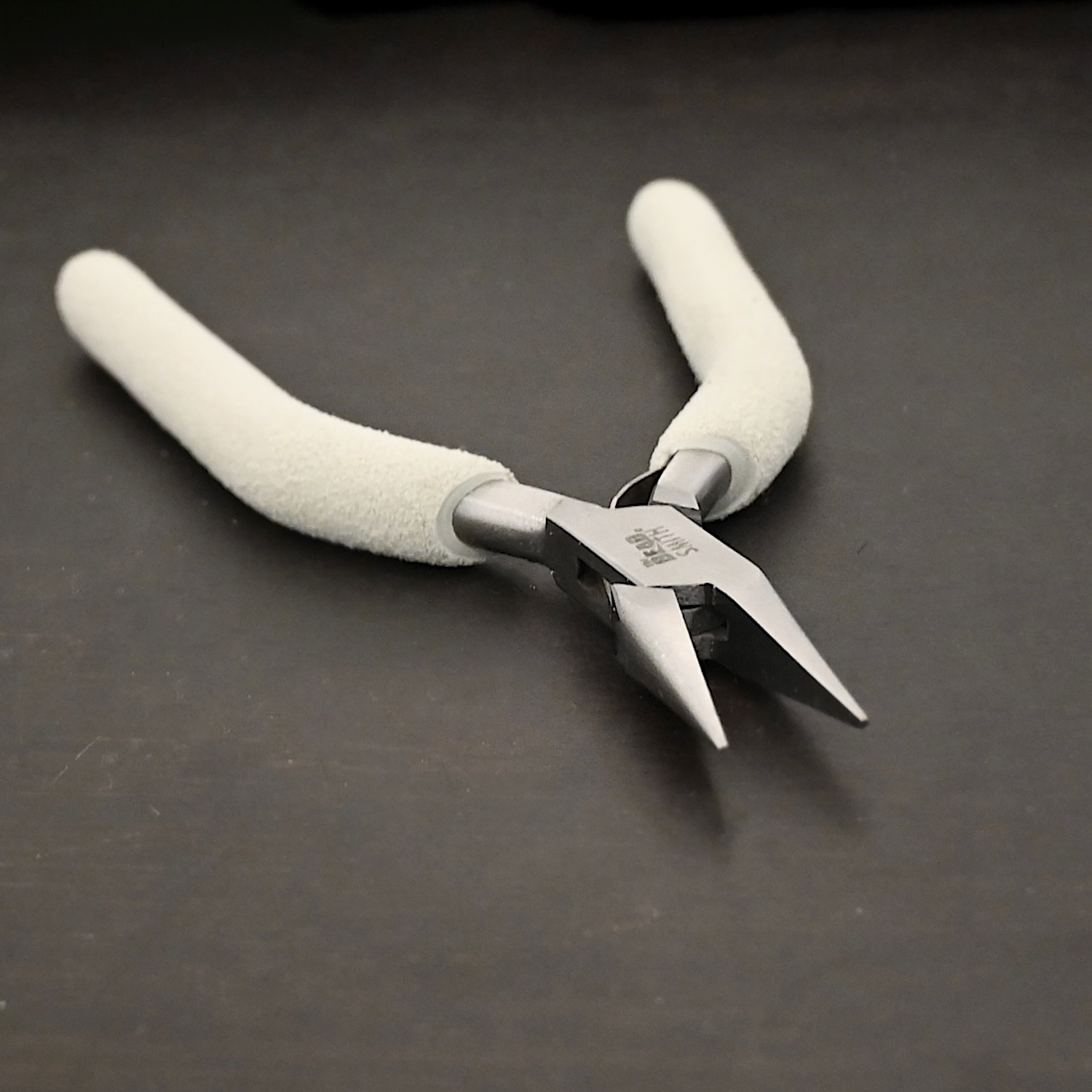 Pliers included in kit - stainless steel and white foam handle shown on dark background