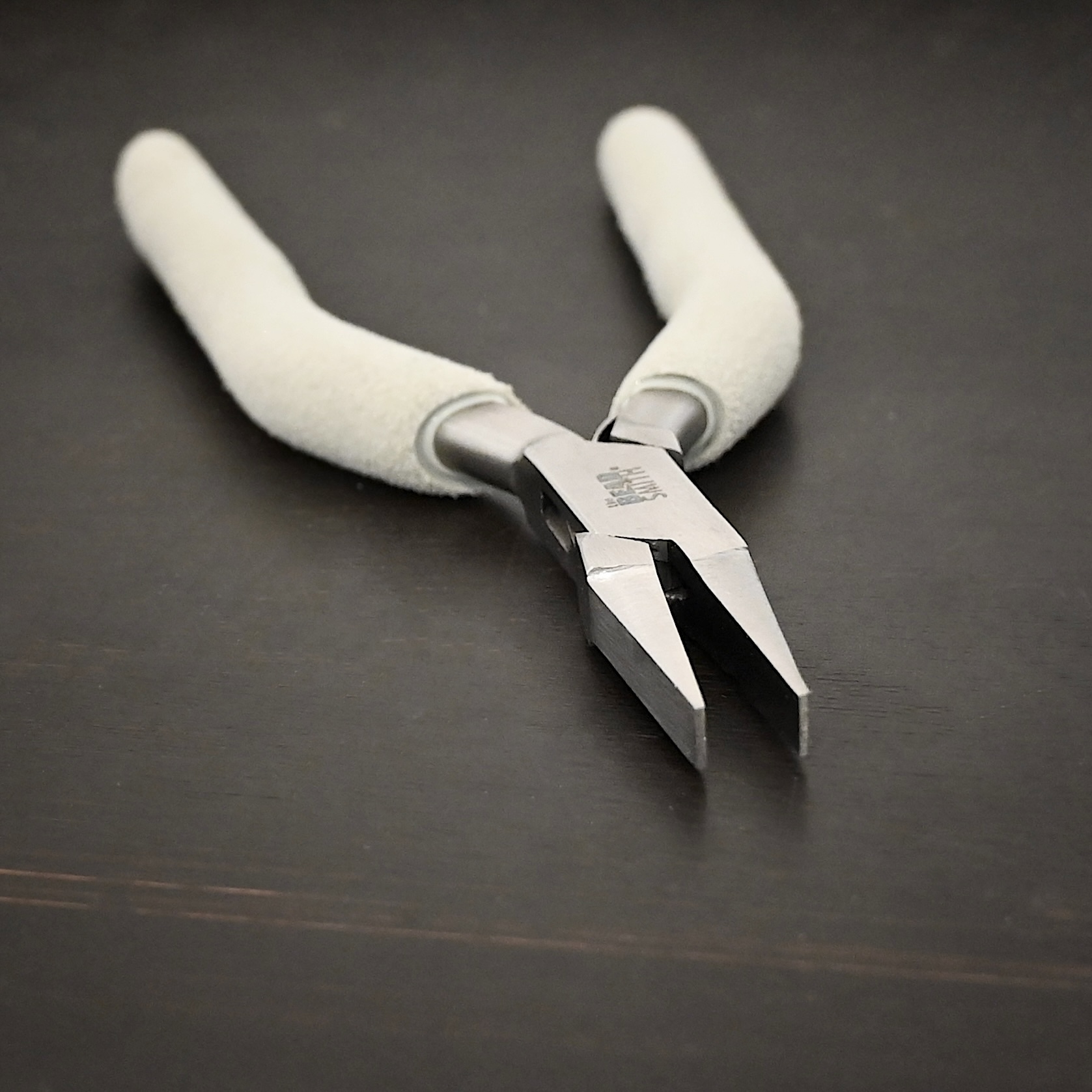 Flat Jaw Pliers included in kit - stainless steel and white foam handle shown on dark background