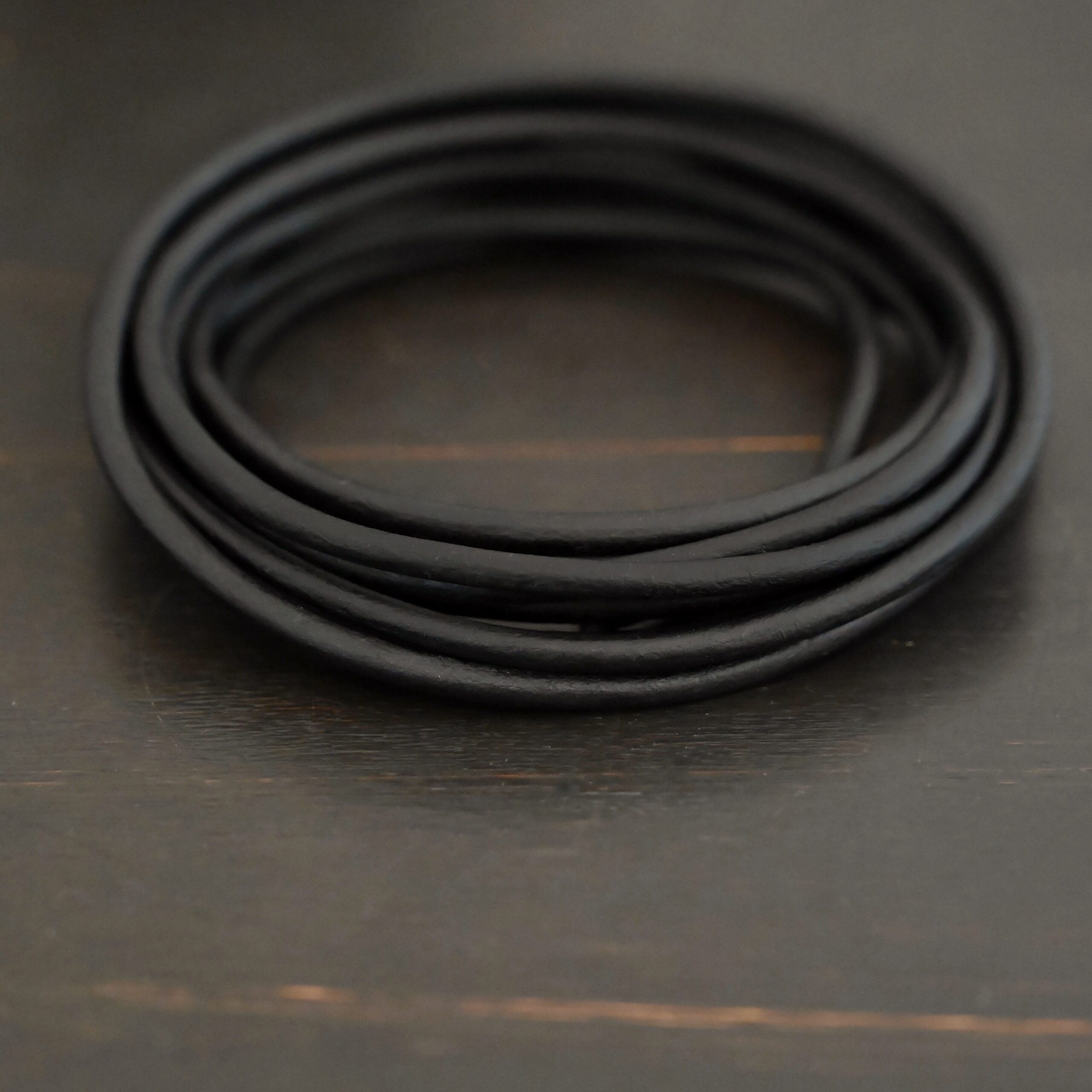 Genuine Natural 3mm black leather on dark background