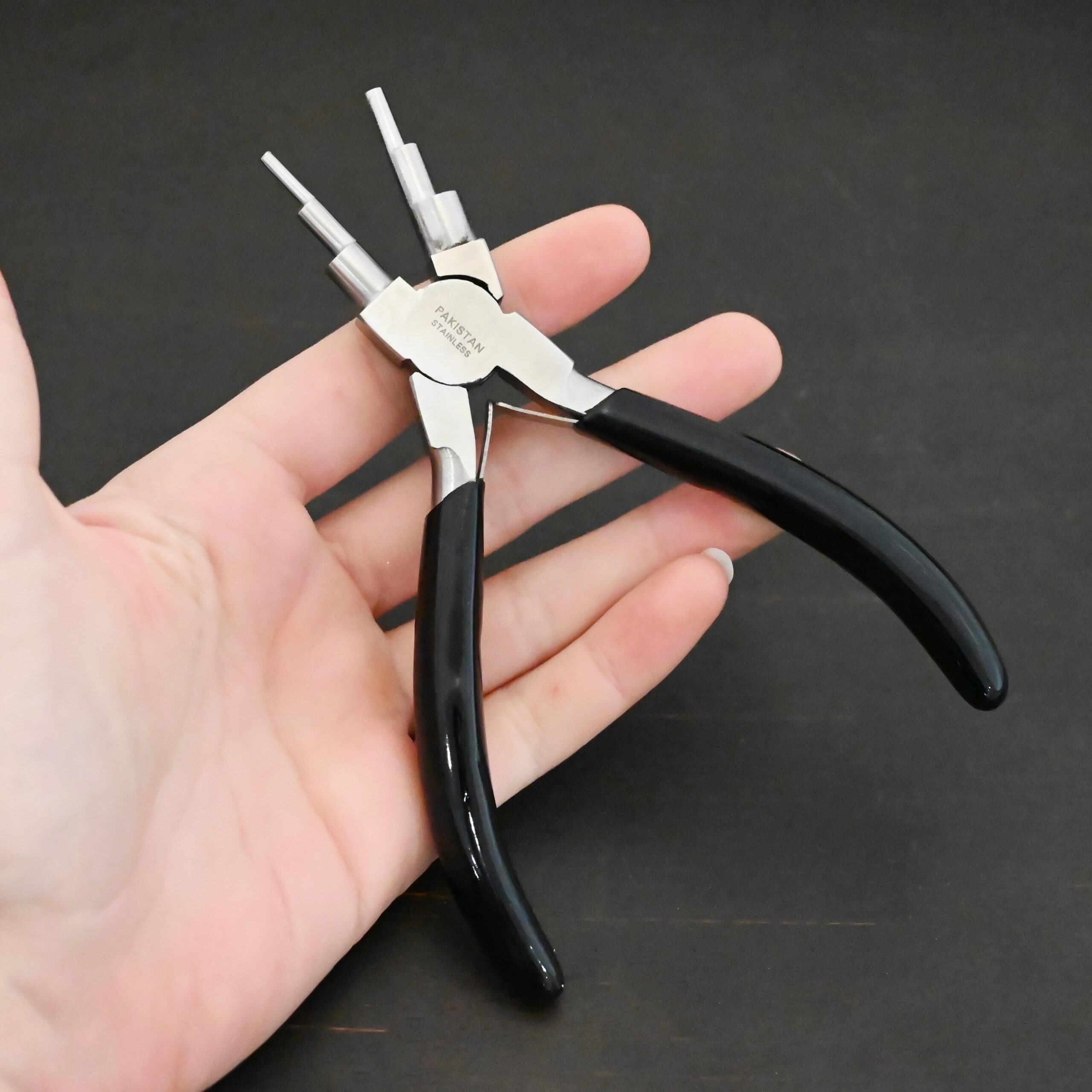 Double Stepped Mandrel Pliers - Black rubber handle shown in hand
