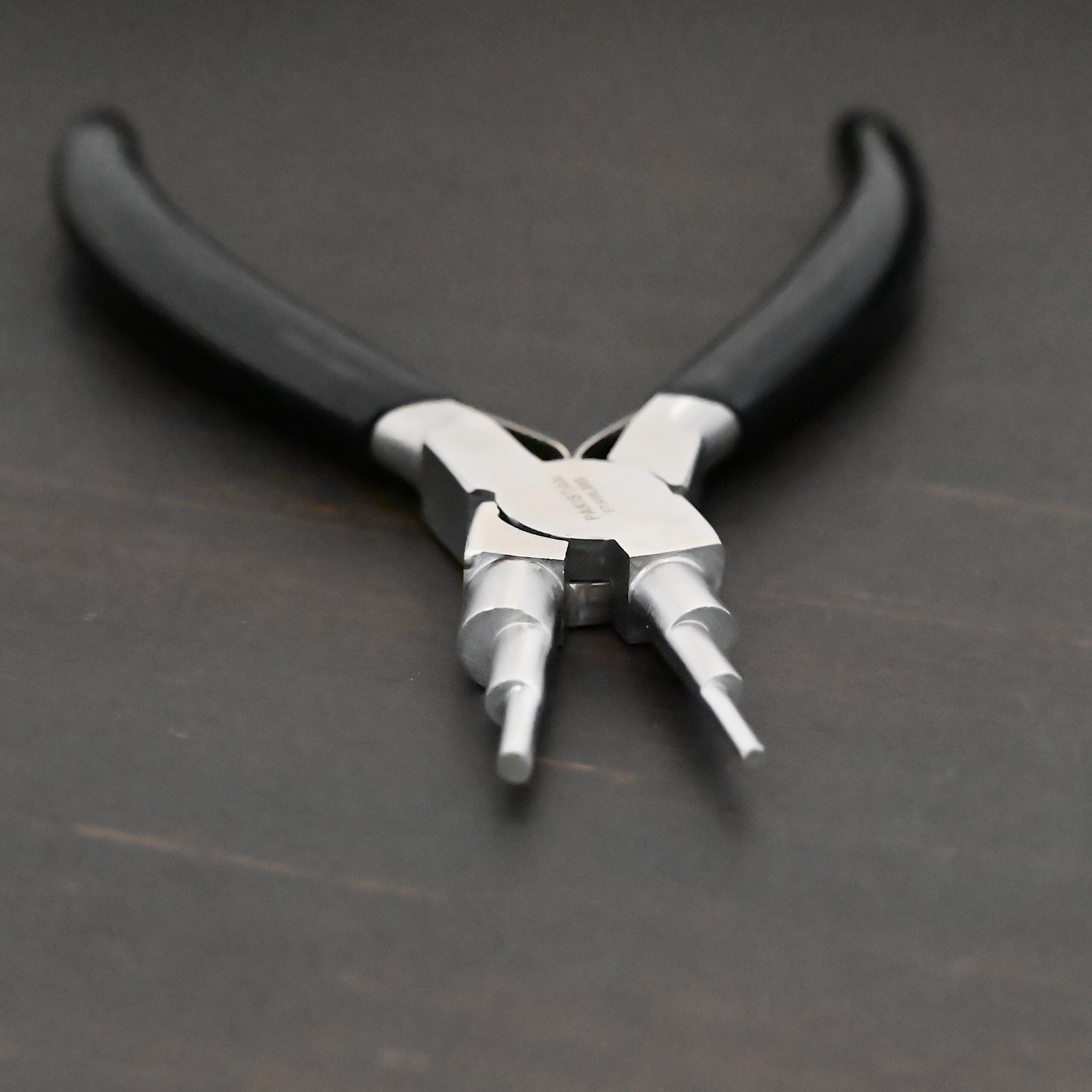 Double Stepped Mandrel Pliers - Black rubber handle shown on dark background