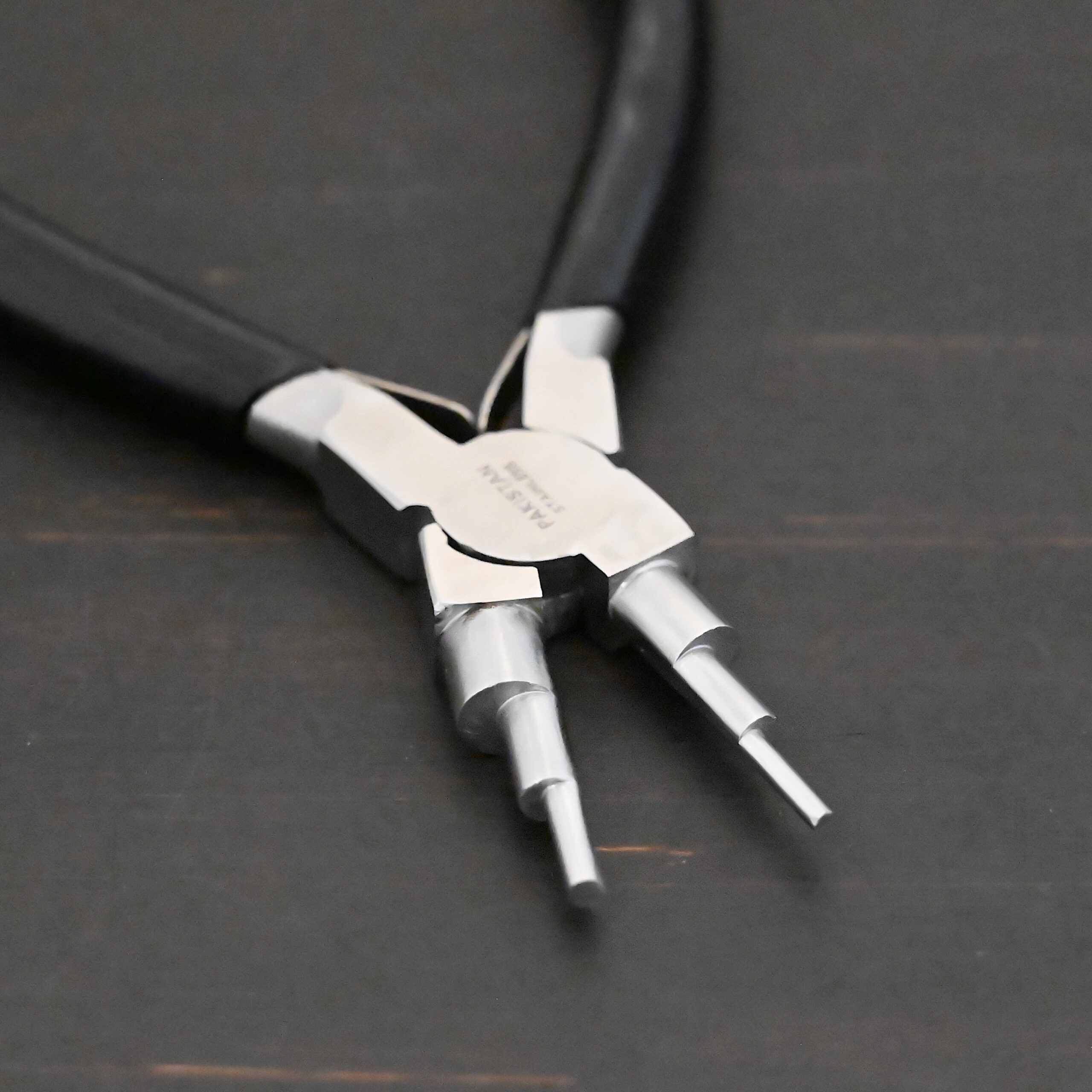 Double Stepped Mandrel Pliers - Black rubber handle shown on dark background