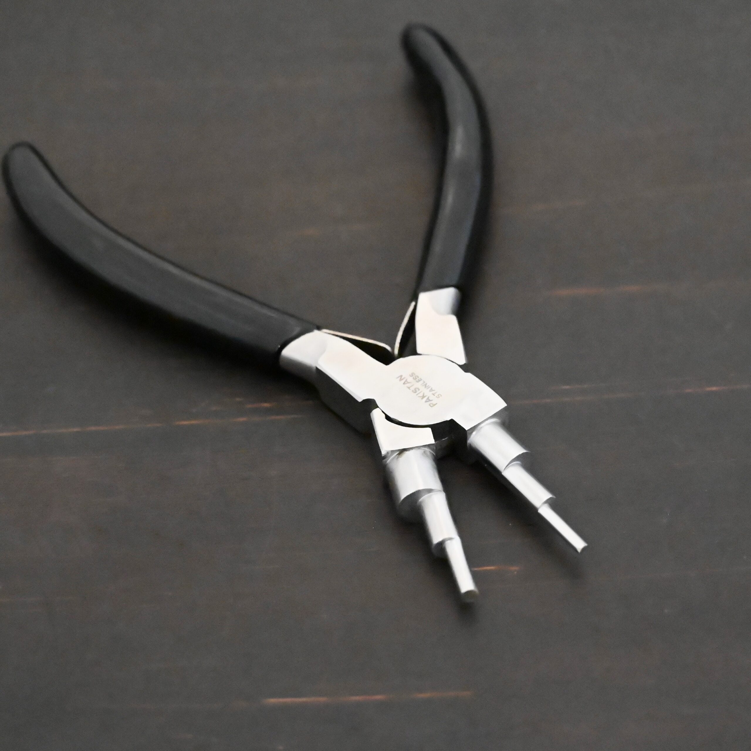 Double Stepped Mandrel Pliers - Black rubber handle shown on dark background