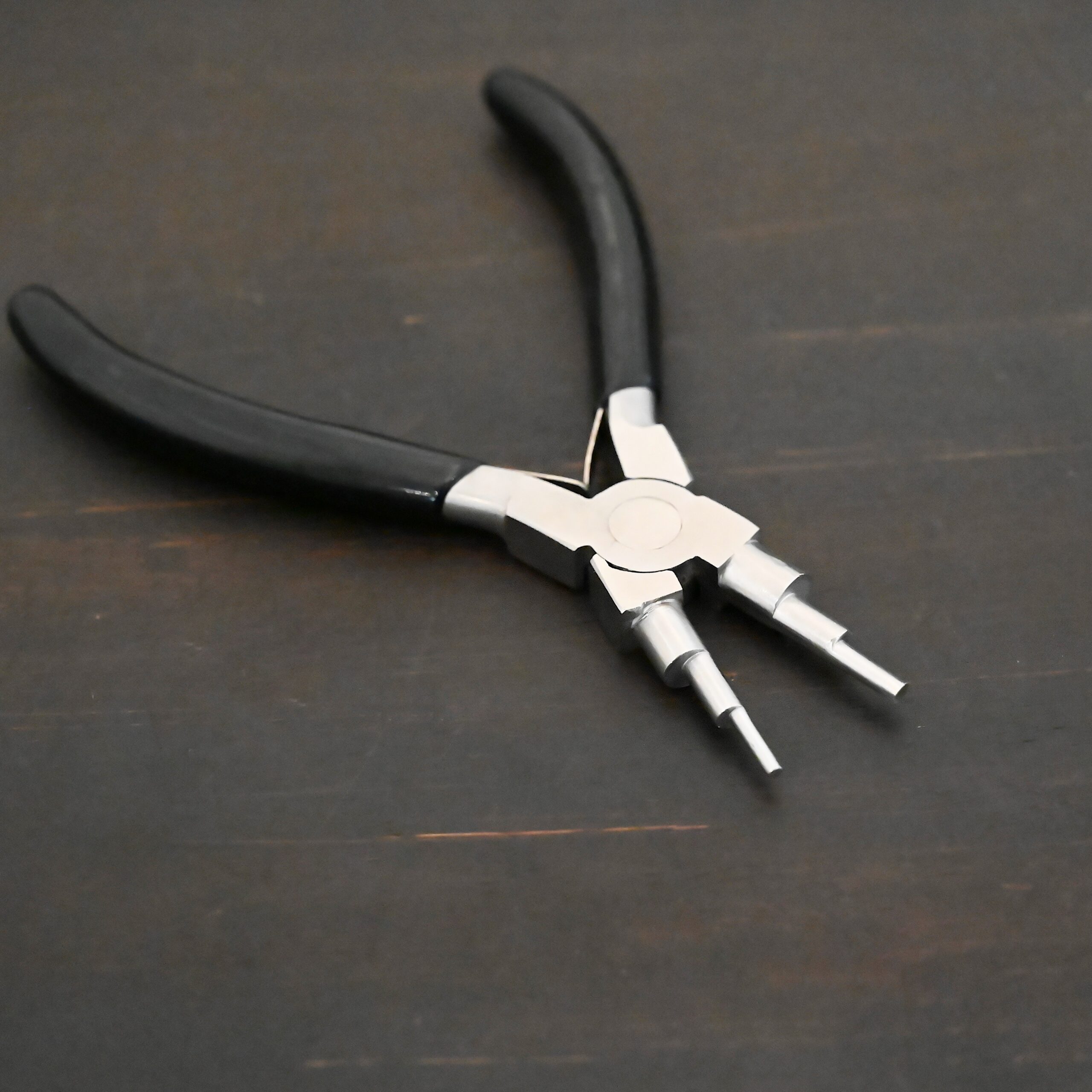 Double Stepped Mandrel Pliers - Black rubber handle shown on dark background