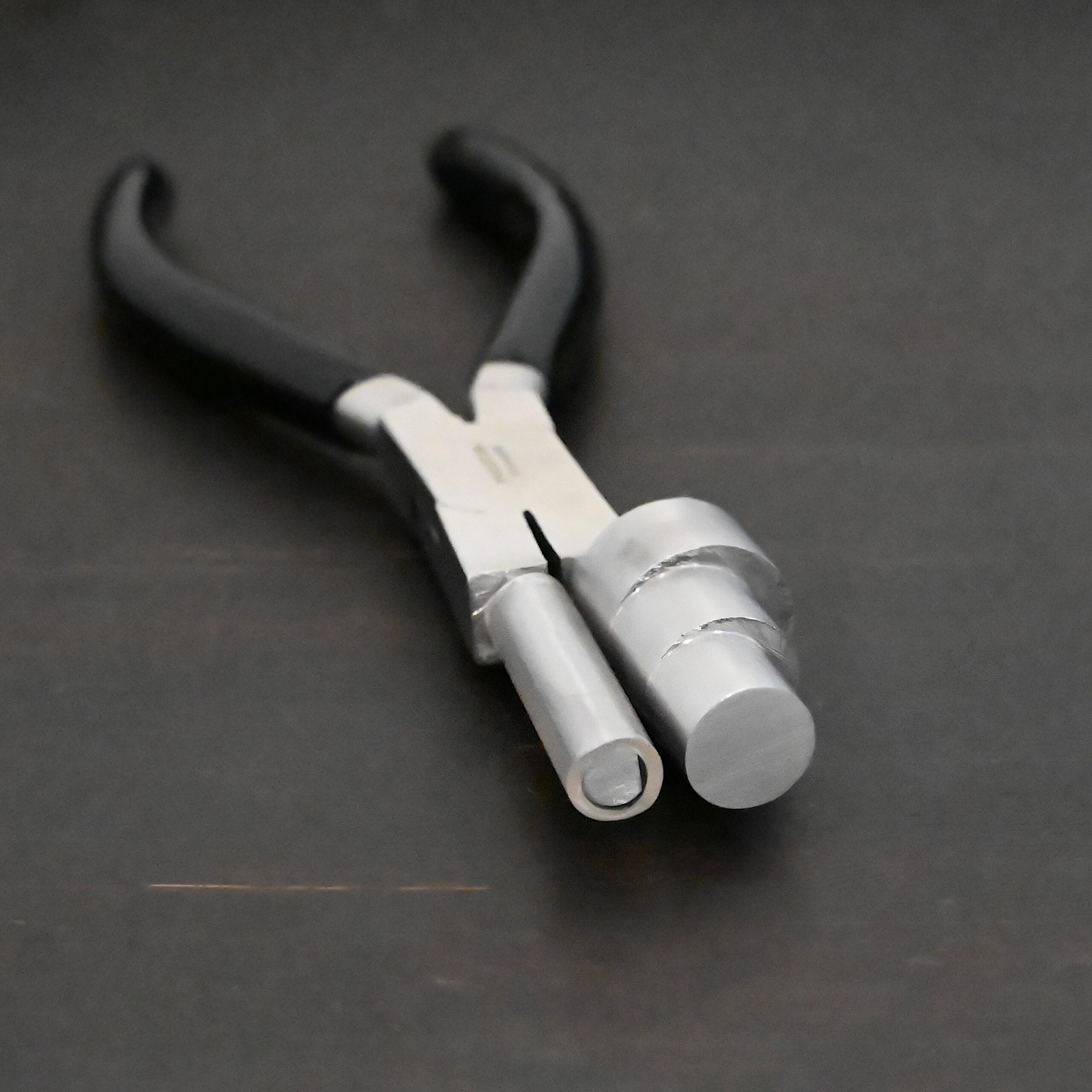 XL Stepped Mandrel Pliers - Black rubber handle shown on dark background