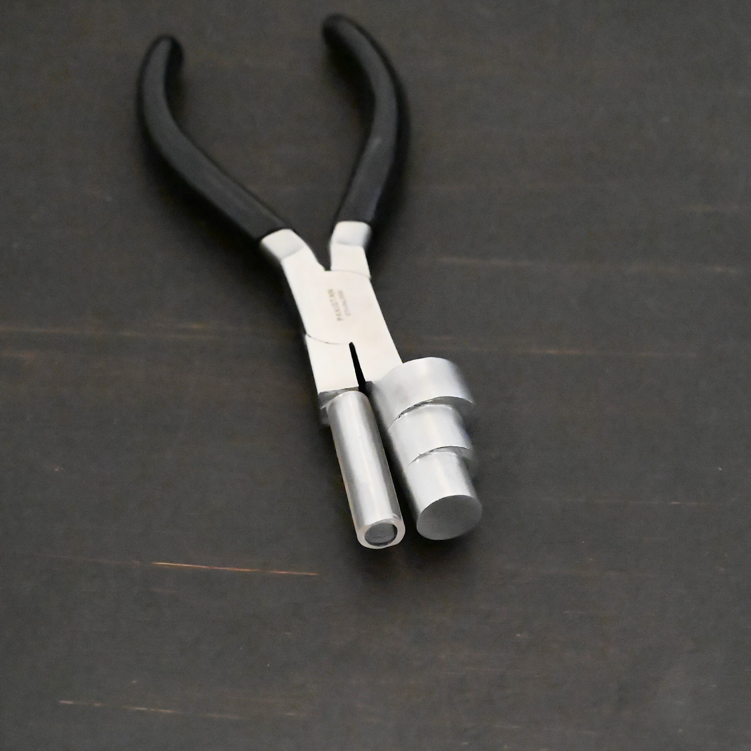 XL Stepped Mandrel Pliers - Black rubber handle shown on dark background