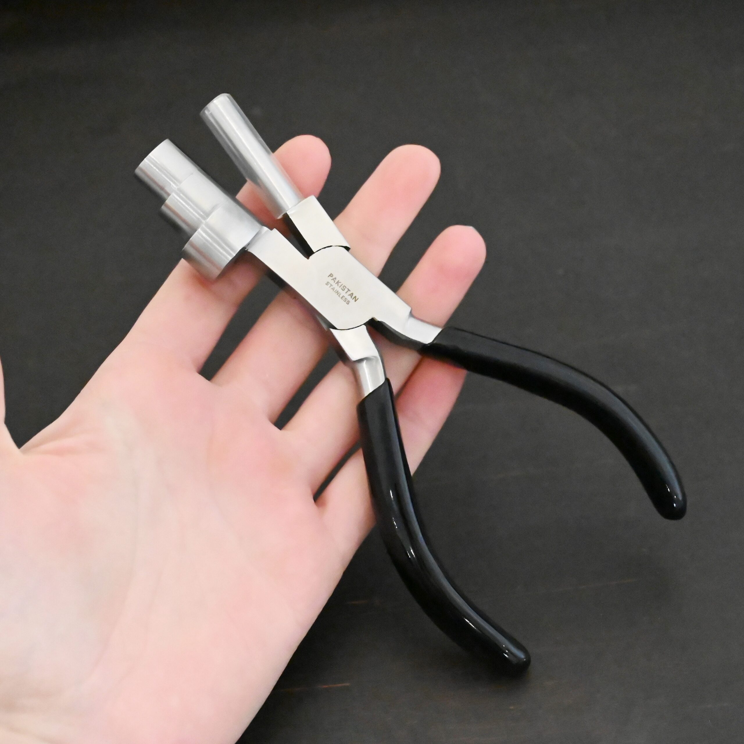 XL Stepped Mandrel Pliers - Black rubber handle shown in hand