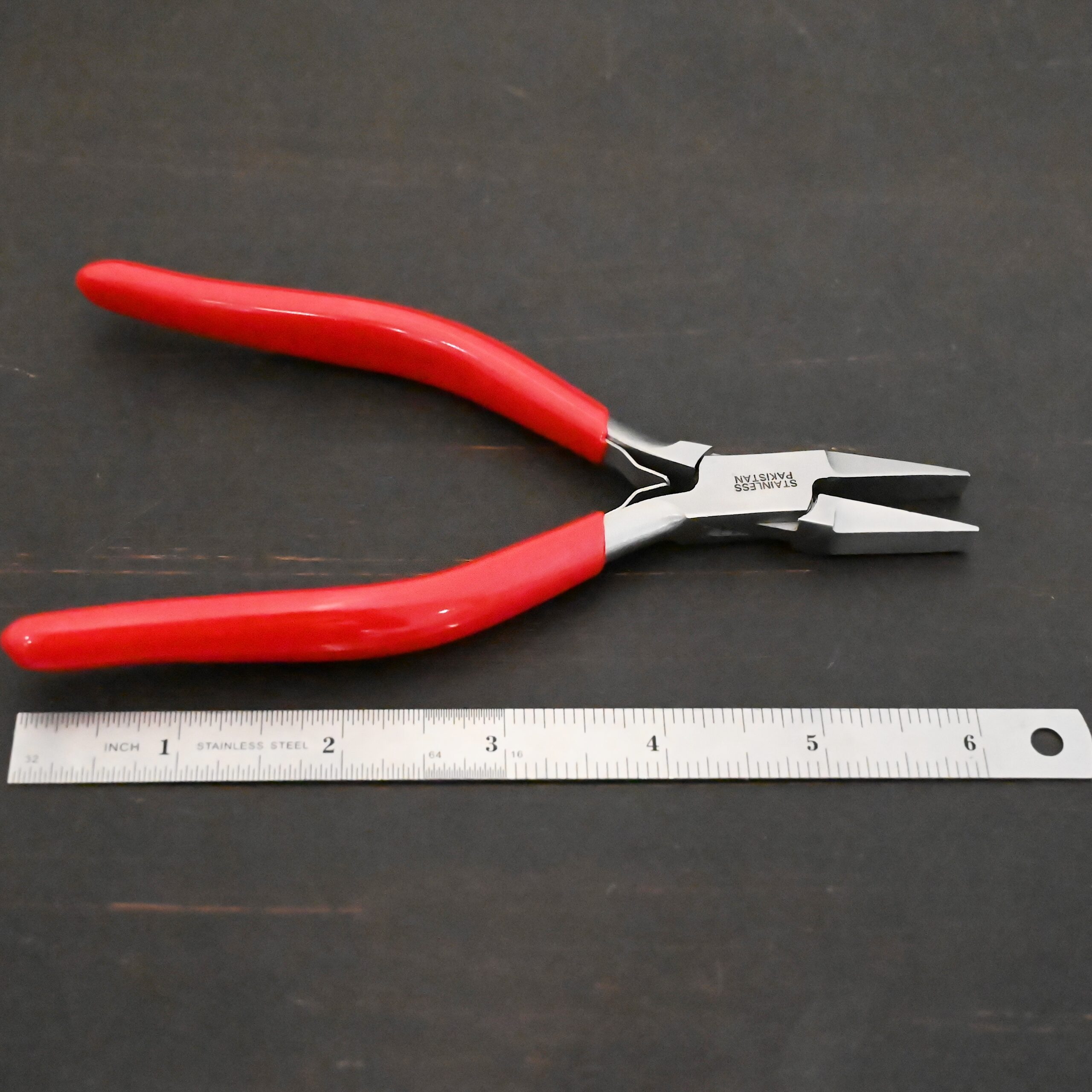Flat Jaw Pliers - Red rubber handle shown next to ruler