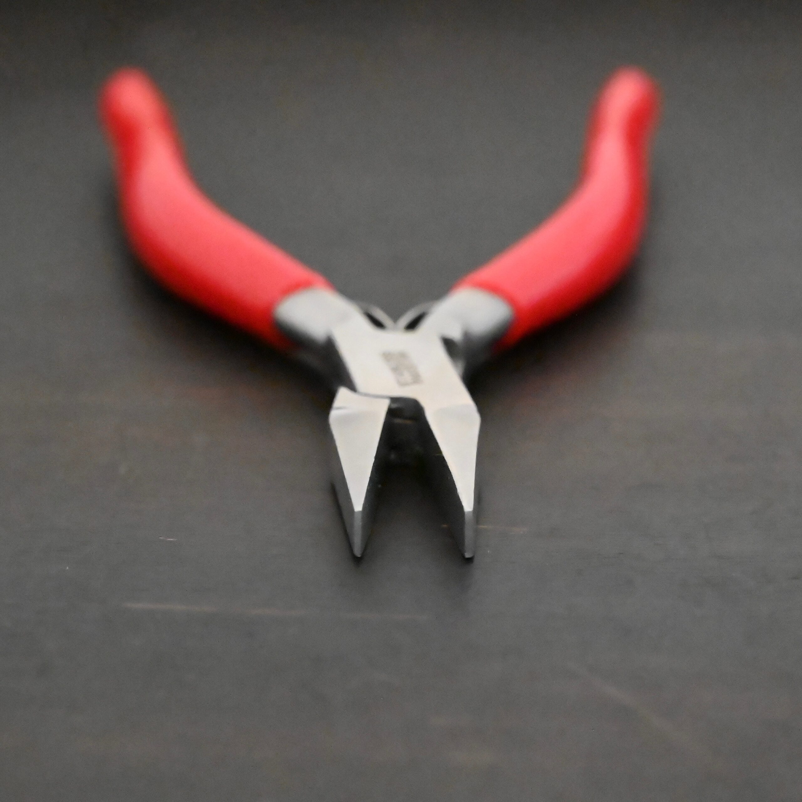 Flat Jaw Pliers - Red rubber handle shown on dark background