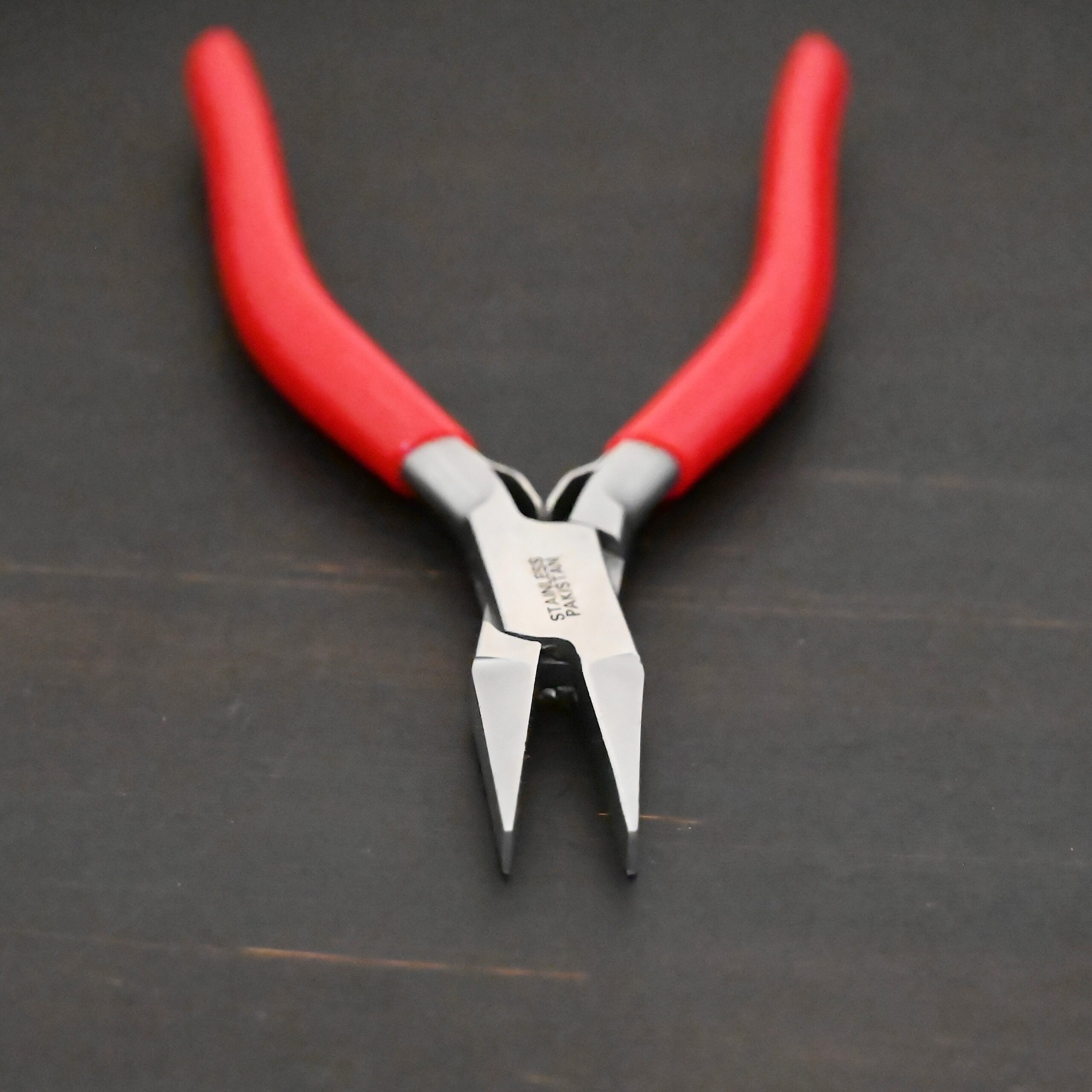 Flat Jaw Pliers - Red rubber handle shown on dark background