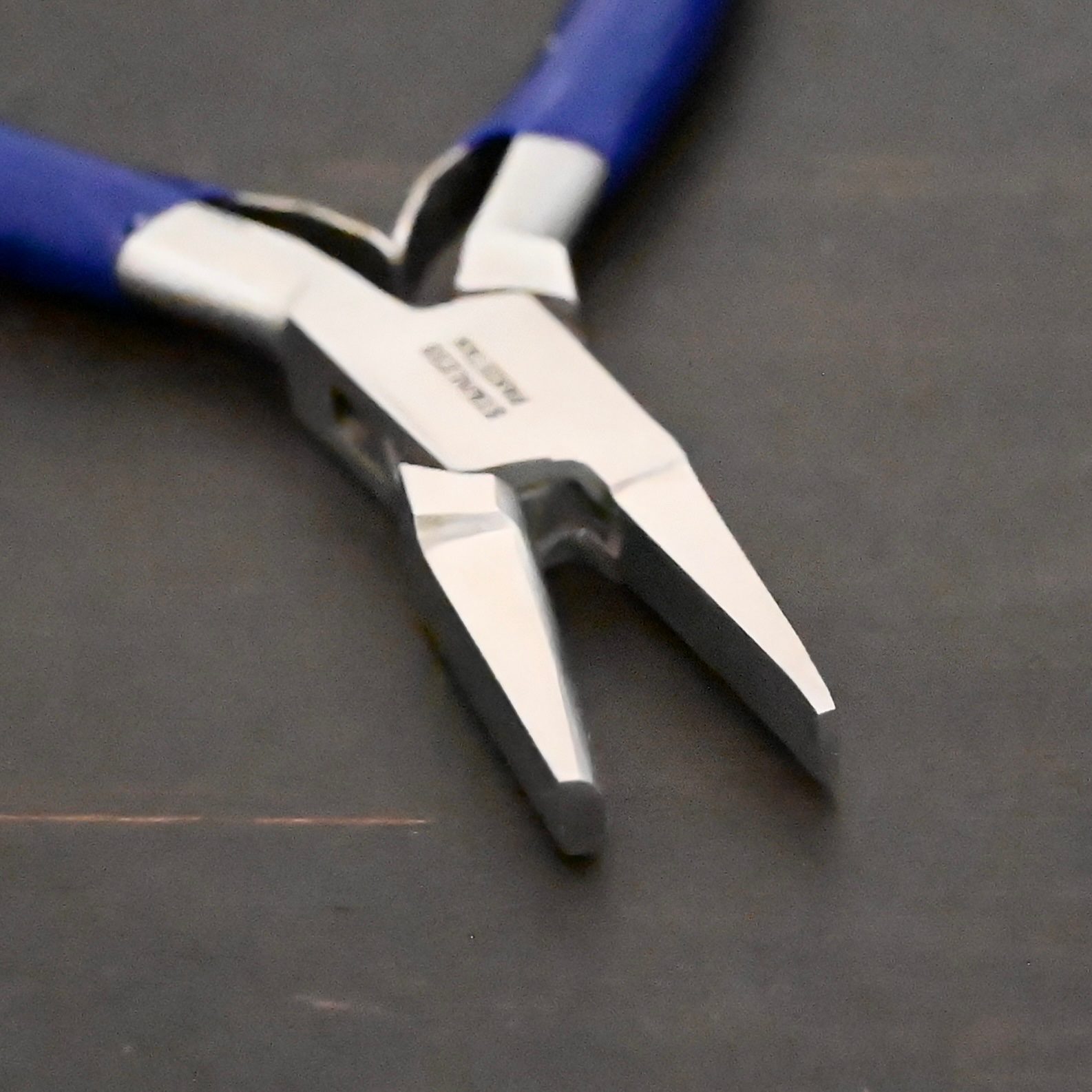 Ring Bending Pliers - Blue rubber handle shown on dark background