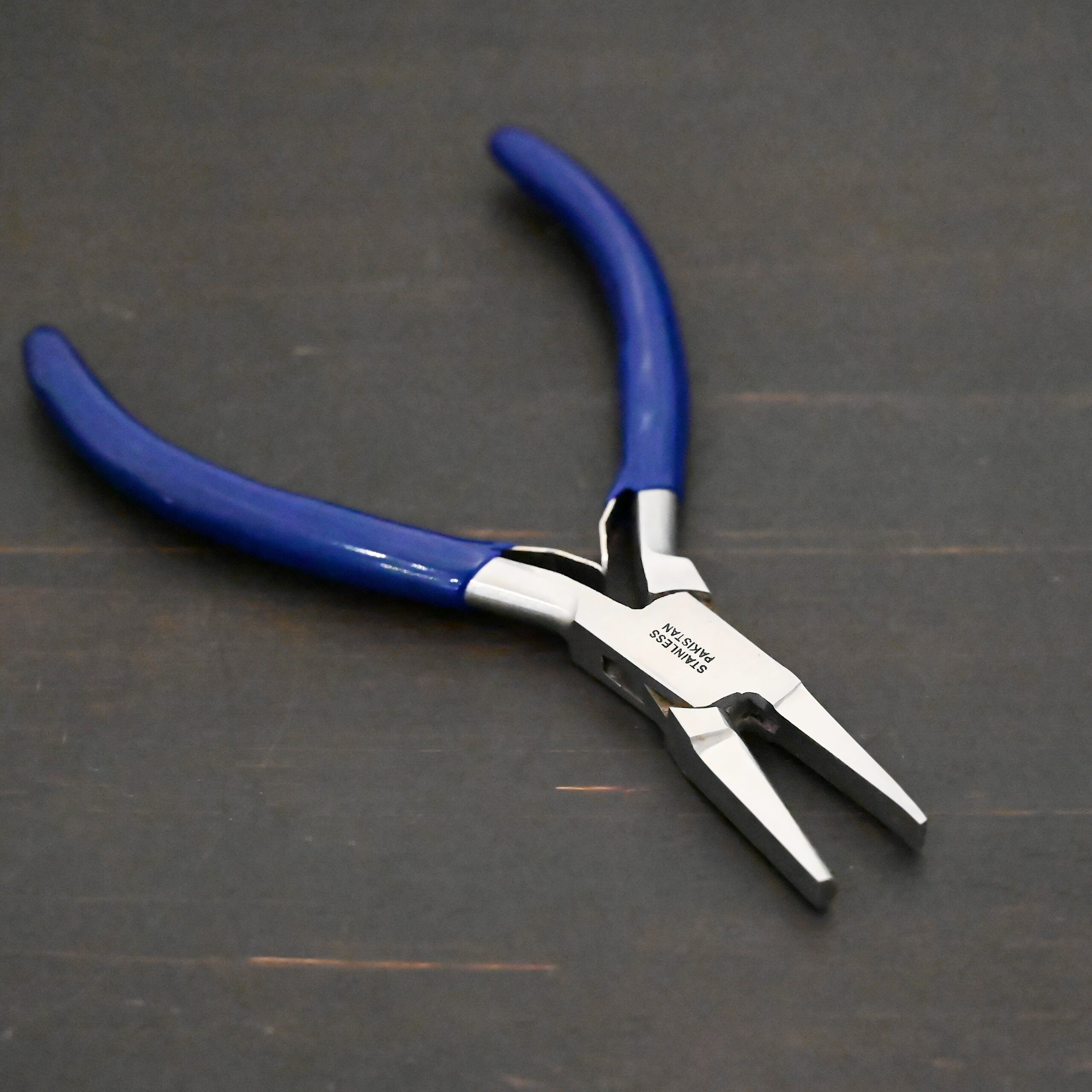 Ring Bending Pliers - Blue rubber handle shown on dark background