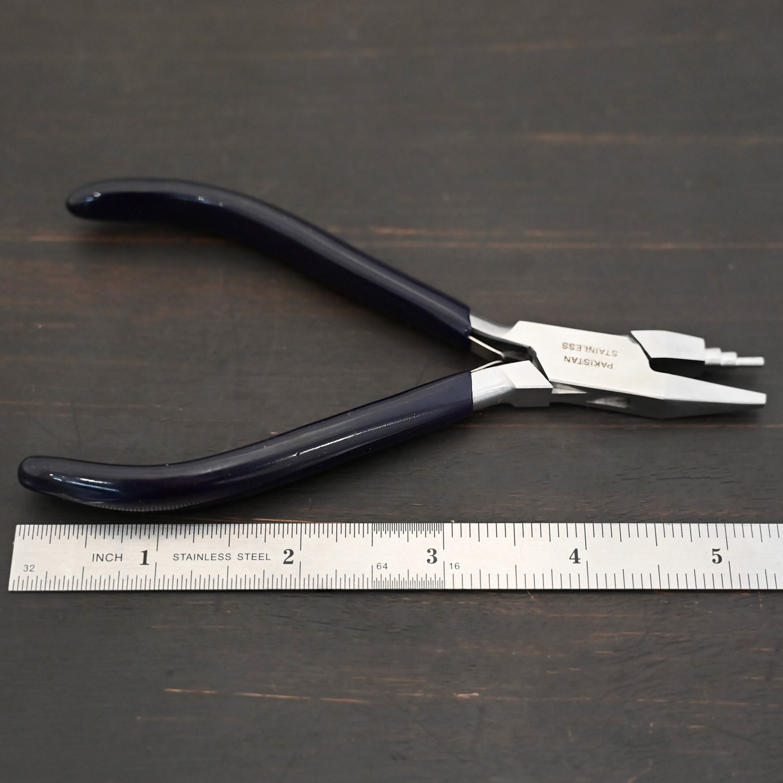 Sawyer - Small Stepped Mandrel Pliers Small Stepped Mandrel pliers - Black rubber handle shown by ruler