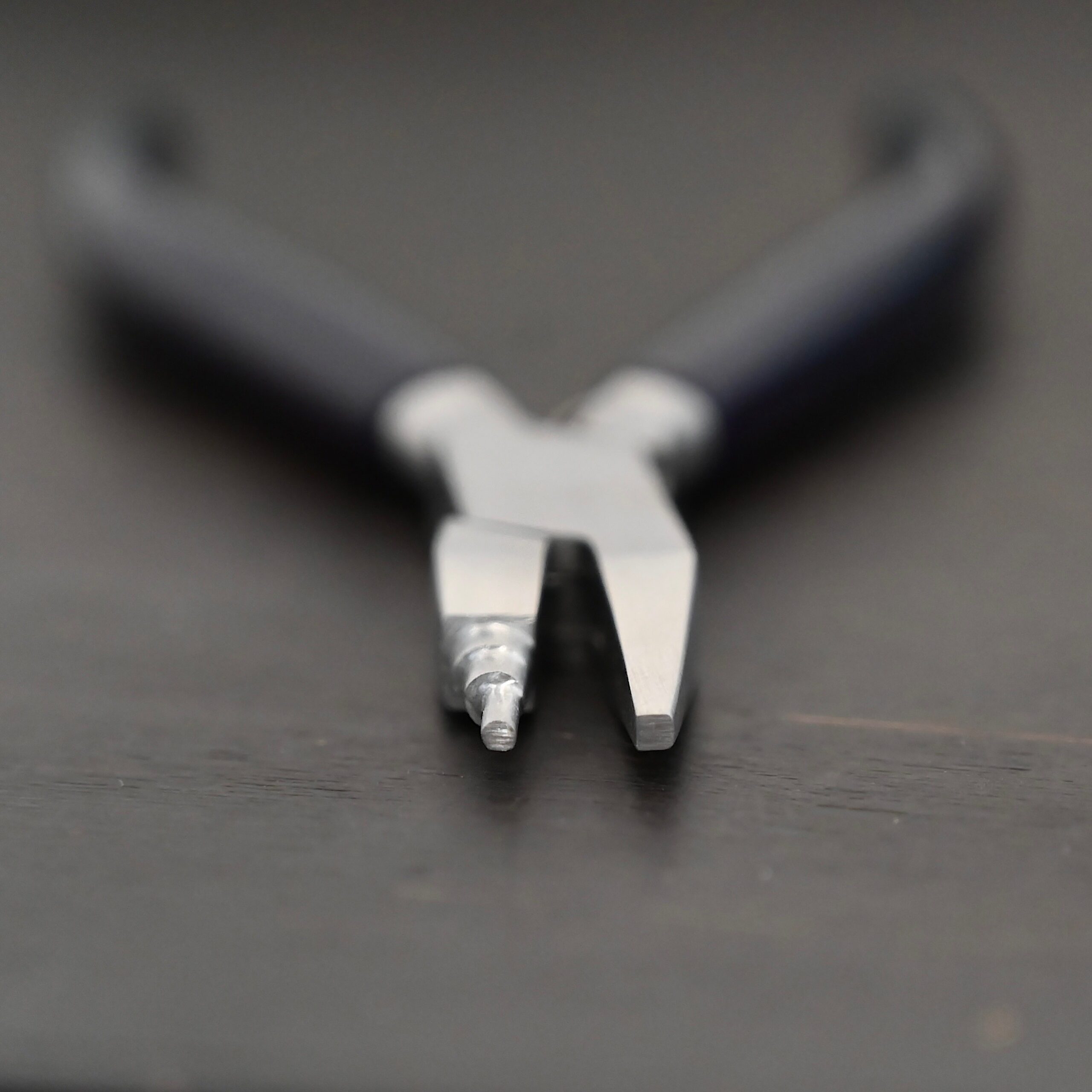 Sawyer - Small Stepped Mandrel Pliers Small Stepped Mandrel pliers - Black rubber handle shown on dark background