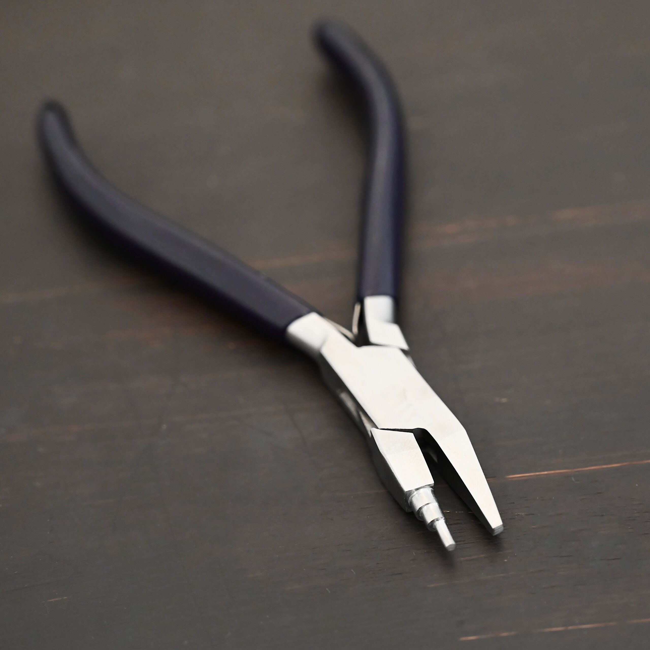 Sawyer - Small Stepped Mandrel Pliers Small Stepped Mandrel pliers - Black rubber handle shown on dark background
