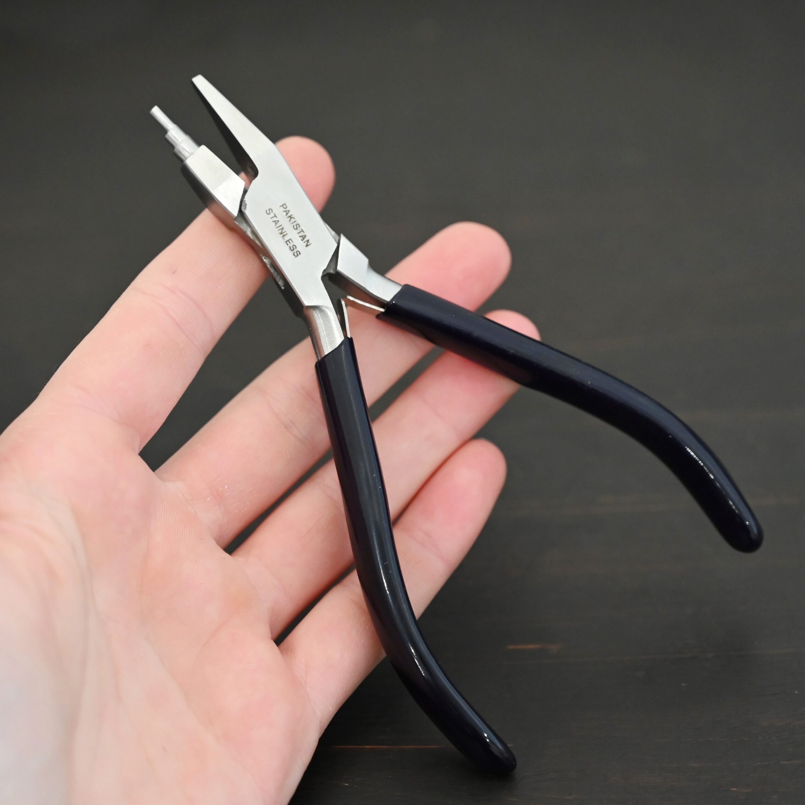 Sawyer - Small Stepped Mandrel Pliers Small Stepped Mandrel pliers - Black rubber handle shown in hand