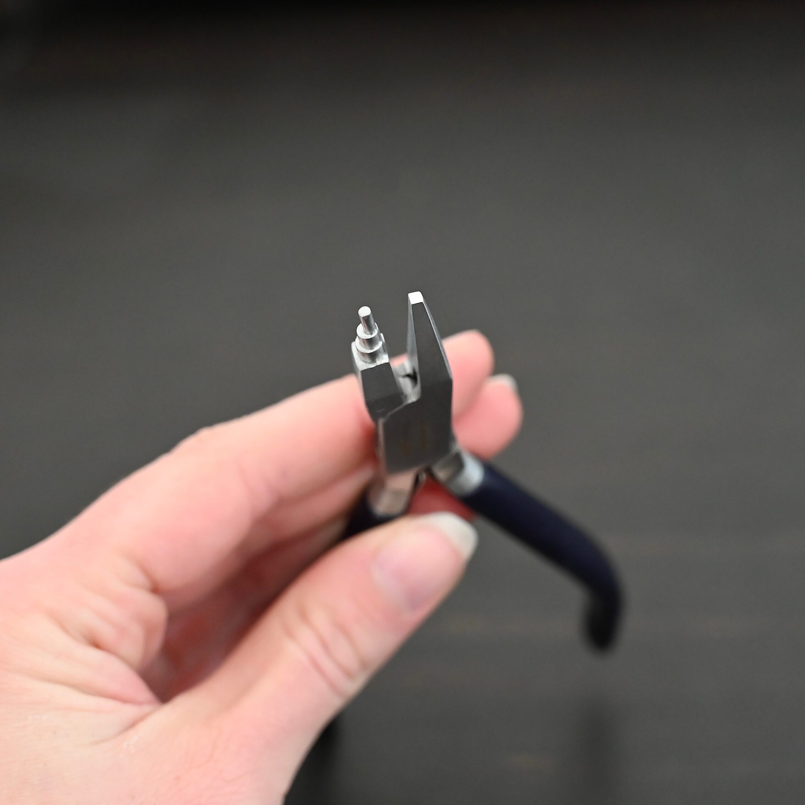 Sawyer - Small Stepped Mandrel Pliers Small Stepped Mandrel pliers - Black rubber handle shown in hand