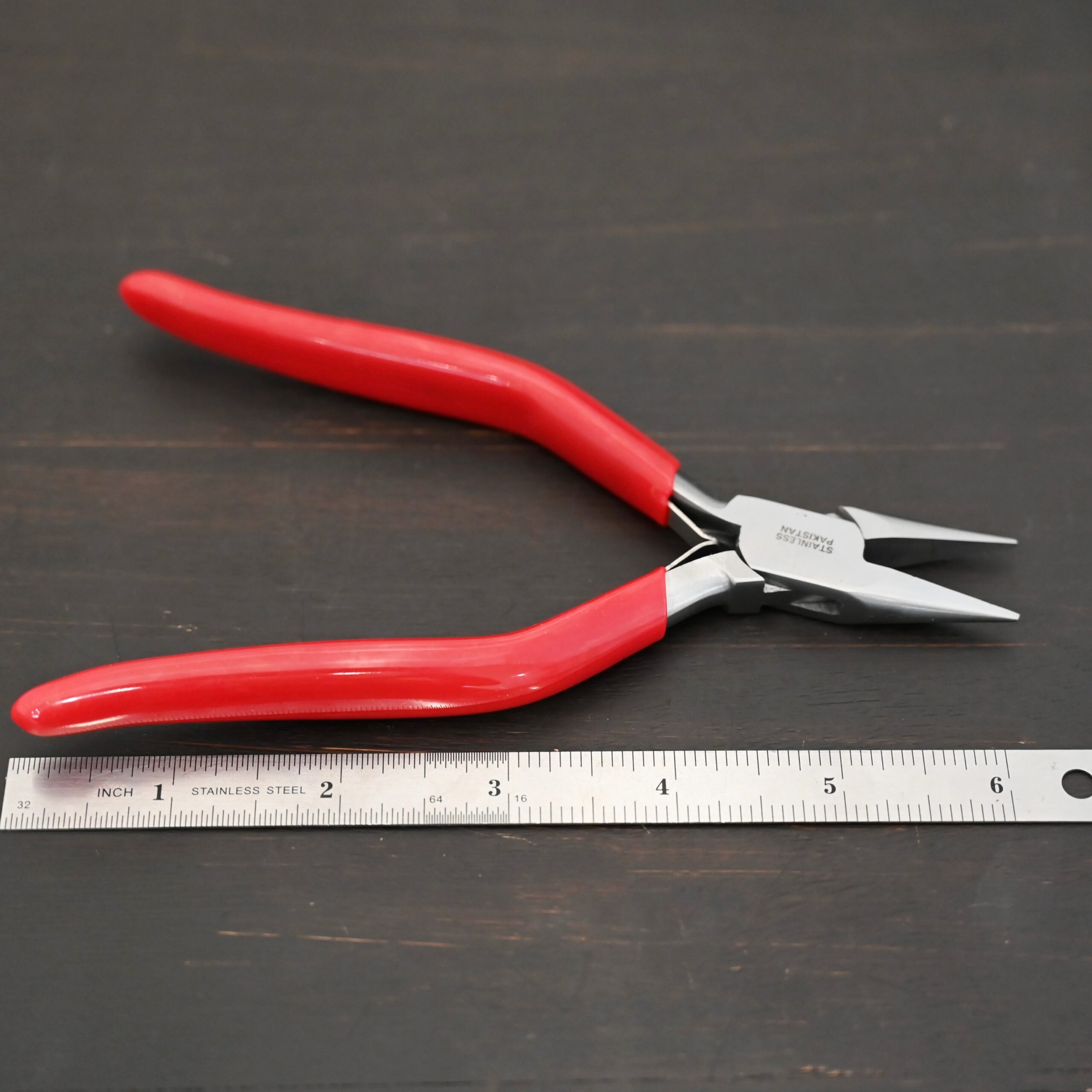 Flat Nosed pliers - Red rubber handle shown by ruler