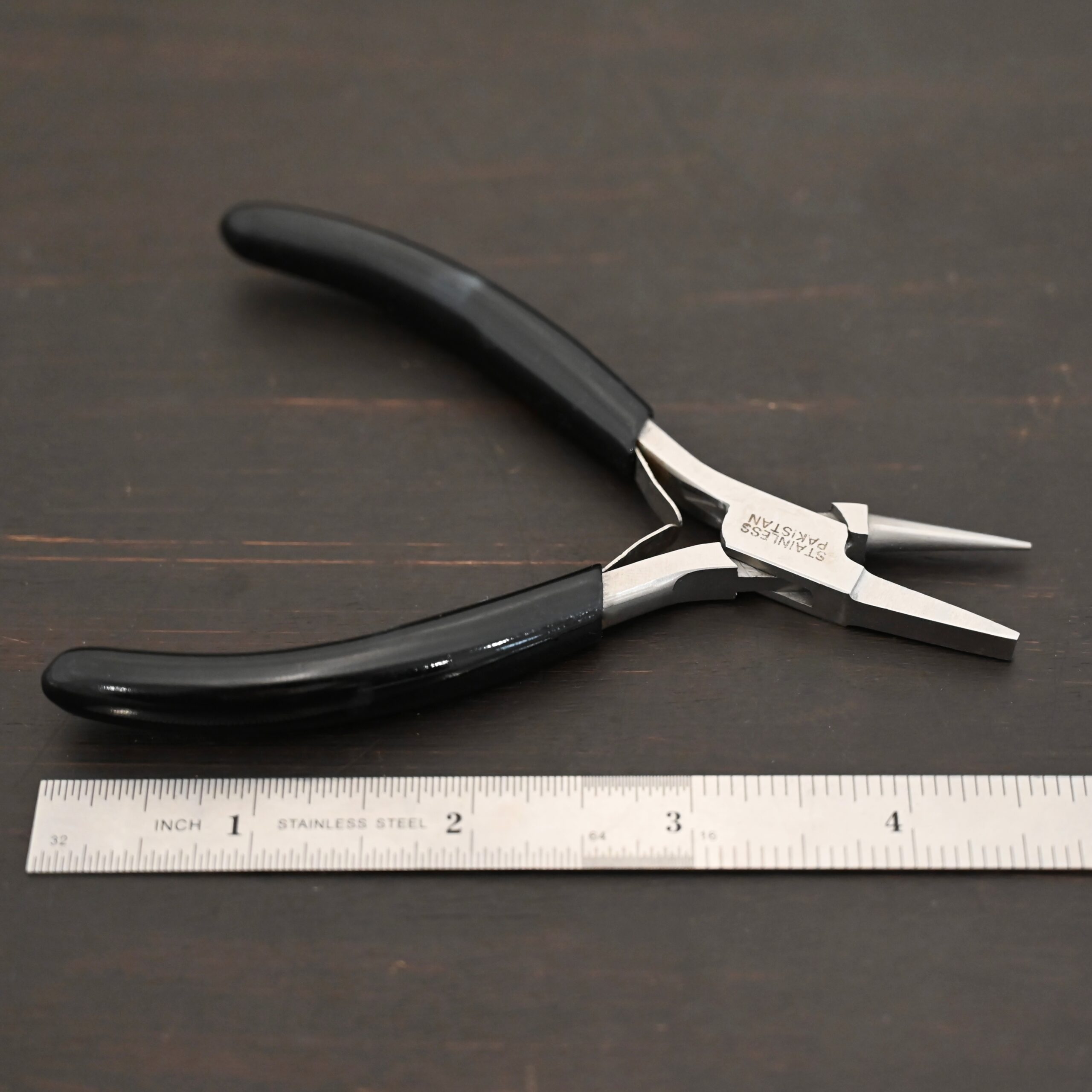 Round/Flat Nosed Pliers - Black Rubber handle shown by ruler
