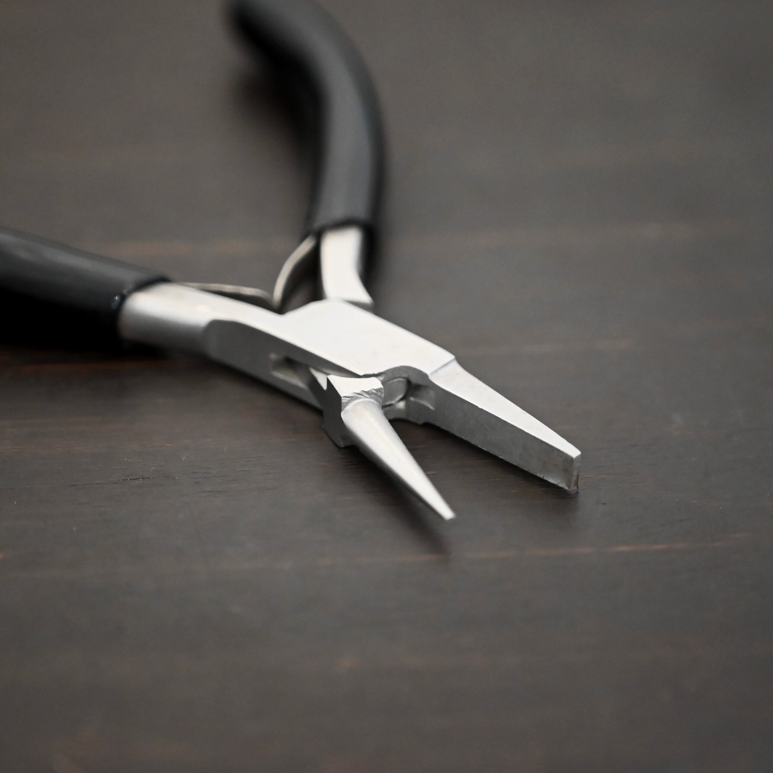 Round/Flat Nosed Pliers - Black Rubber handle shown on dark background