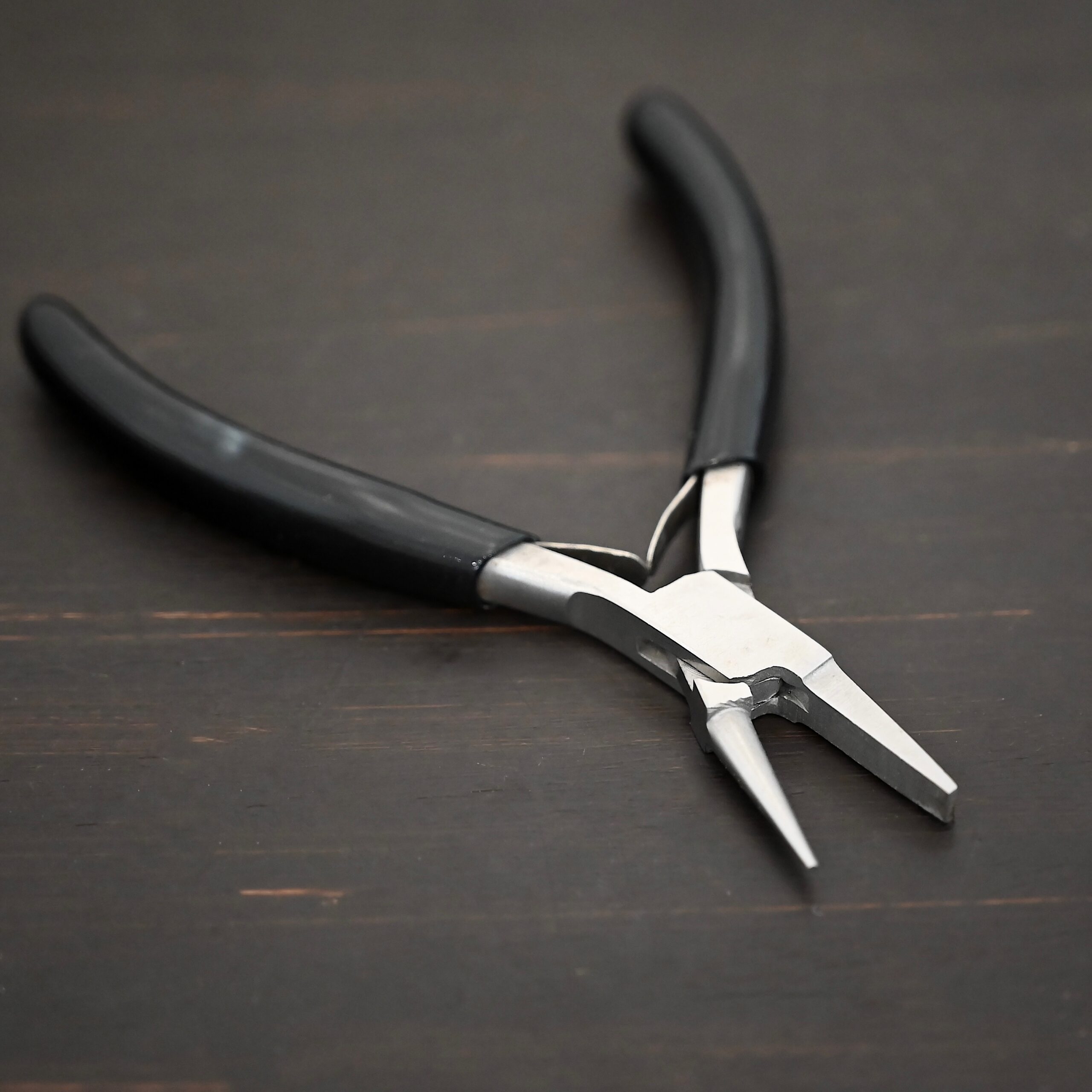 Round/Flat Nosed Pliers - Black Rubber handle shown on dark background