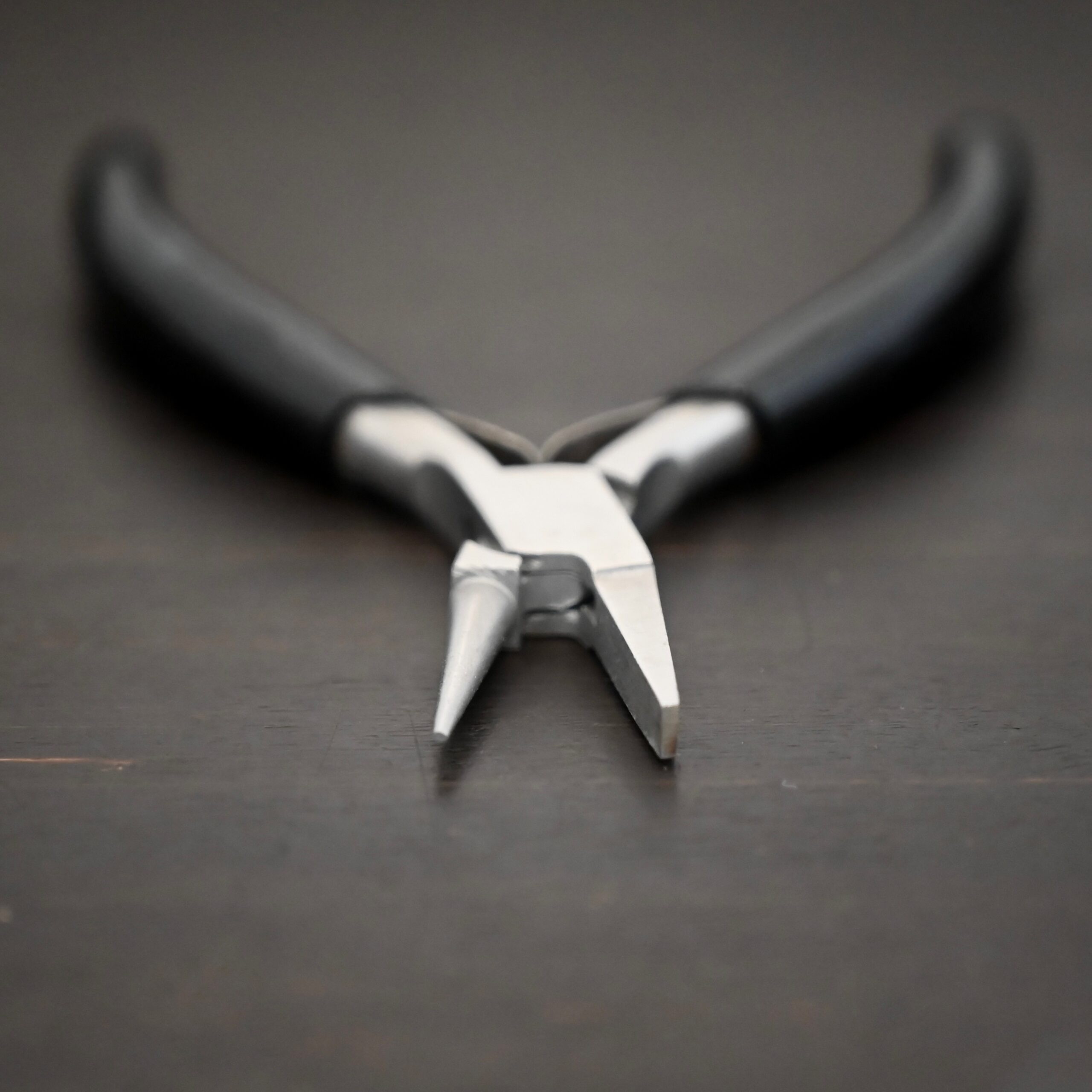 Round/Flat Nosed Pliers - Black Rubber handle shown on dark background