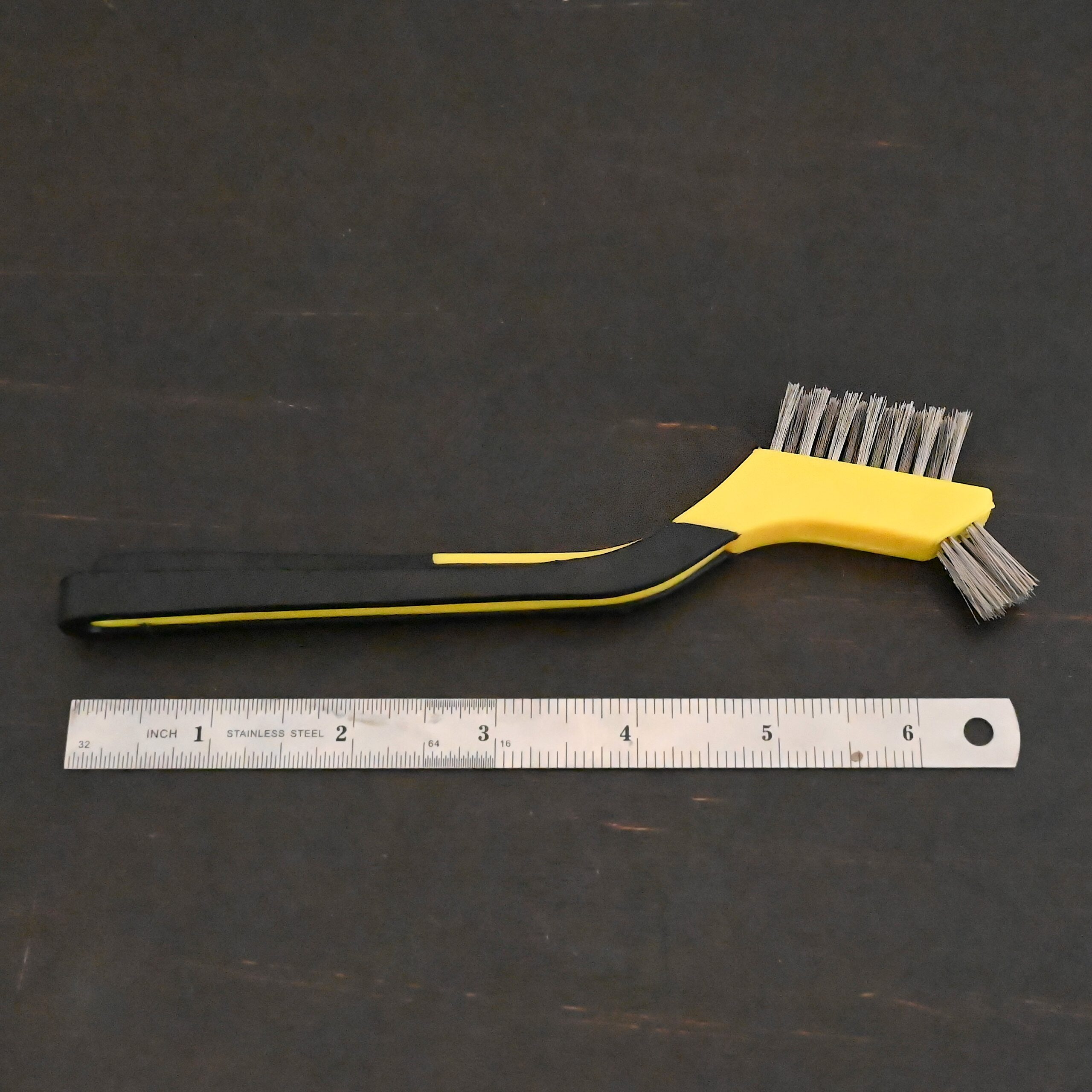 Stainless Steel Wire Brush - black and yellow plastic handle shown next to ruler