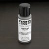 Gel Patina 2oz bottle with black top shown on dar background