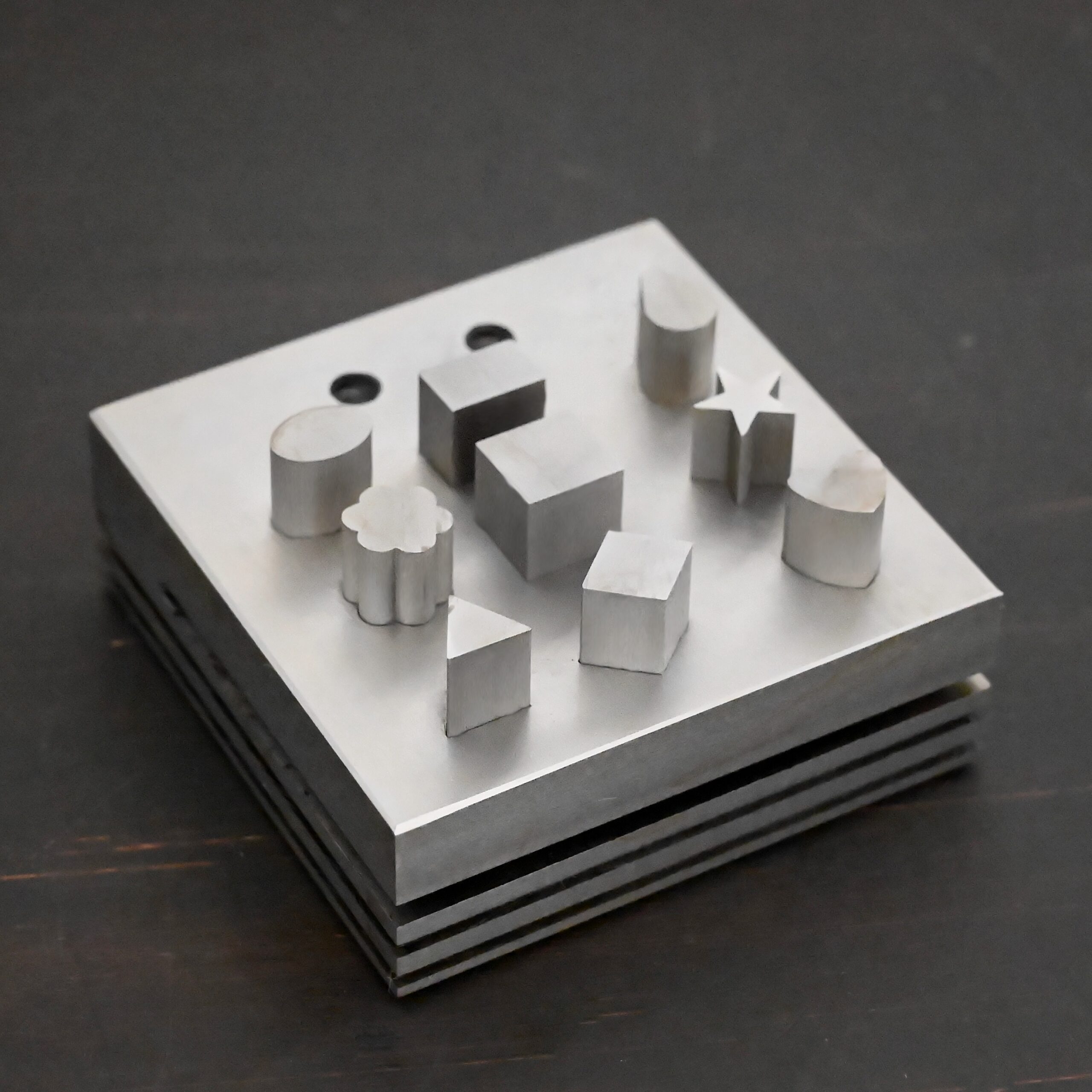 Stainless Steel Disc Cutter Showing all punches on dark background