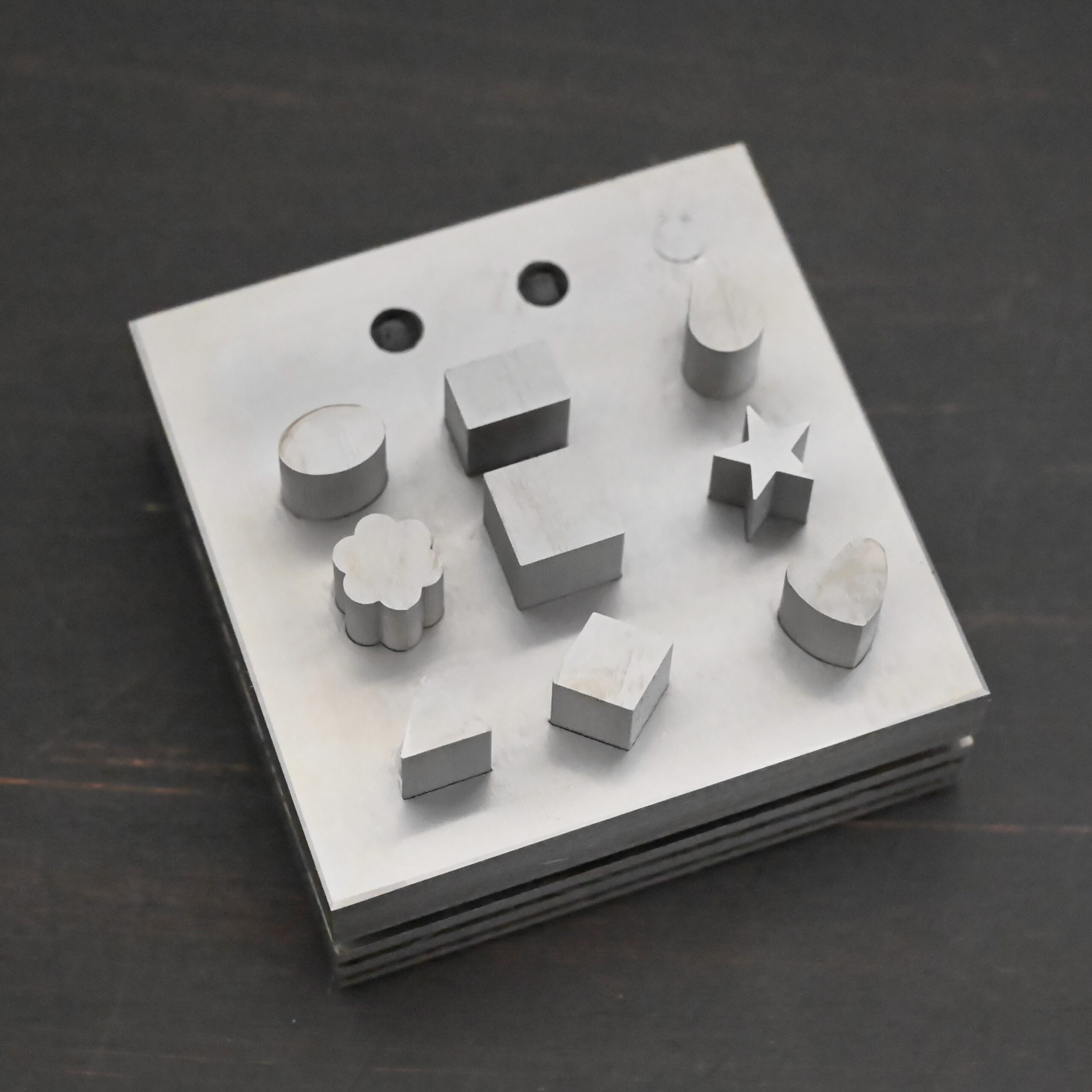 Stainless Steel Disc Cutter Showing all punches on dark background