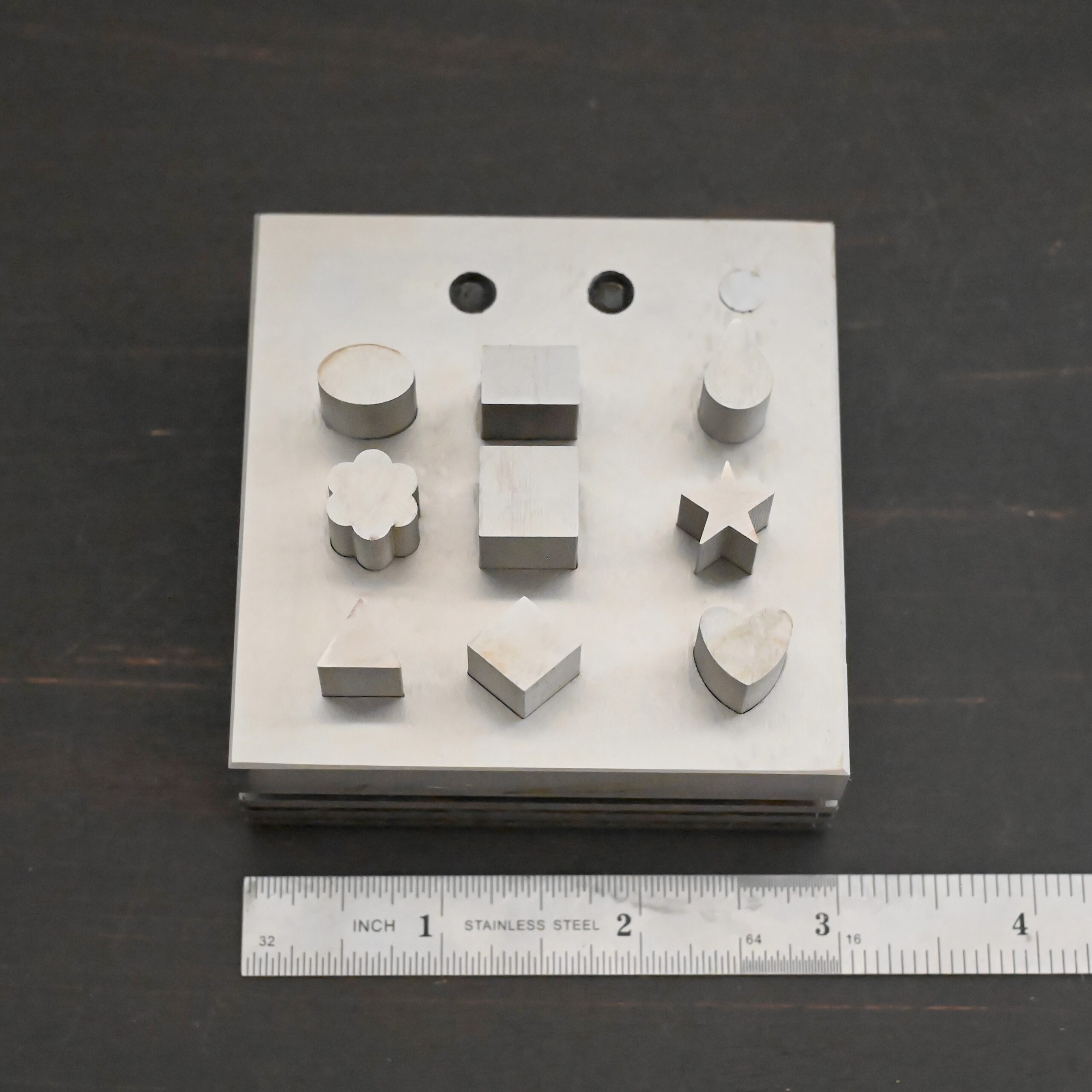 Stainless Steel Disc Cutter Showing all punches shown next to ruler