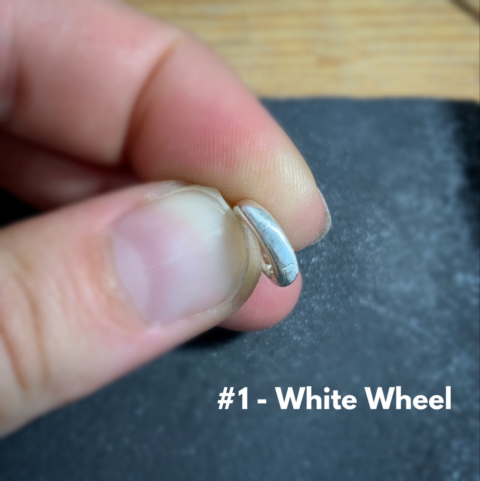 Shows after using the #1 white wheel on stainless steel clasp shown in hand