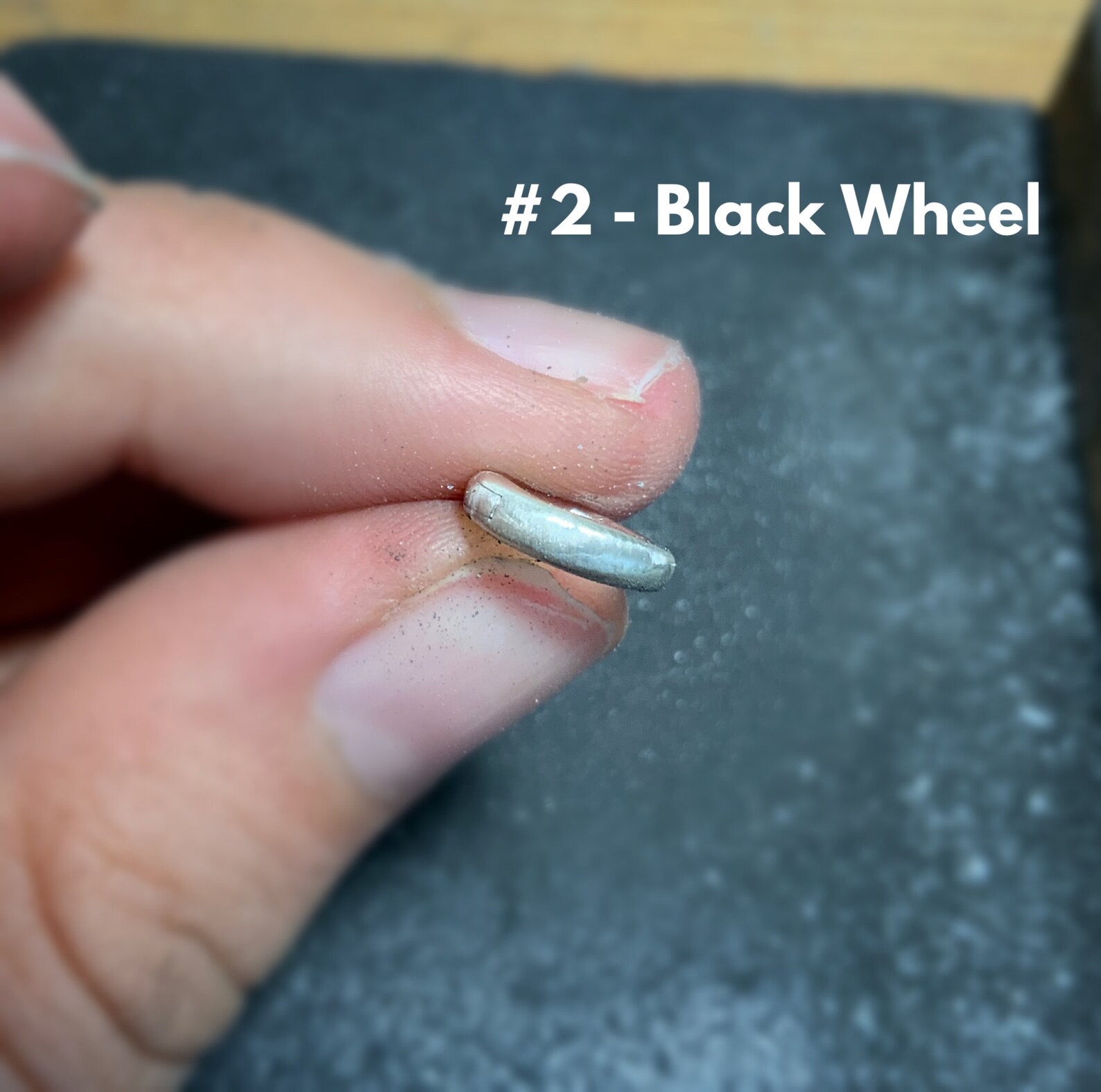 Shows after using the #2 black wheel on stainless steel clasp shown in hand