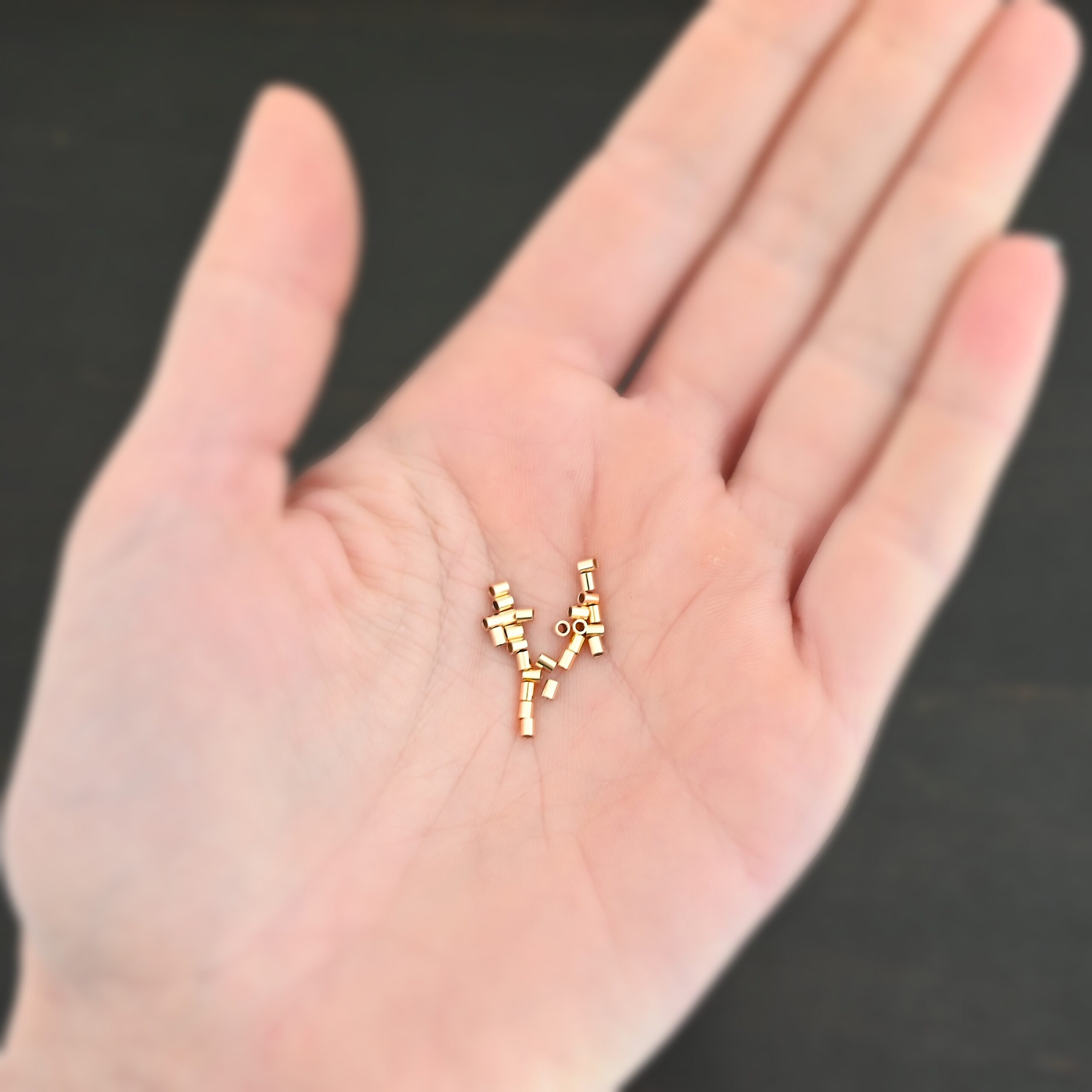 Gold Filled 2mm crimps shown in hand