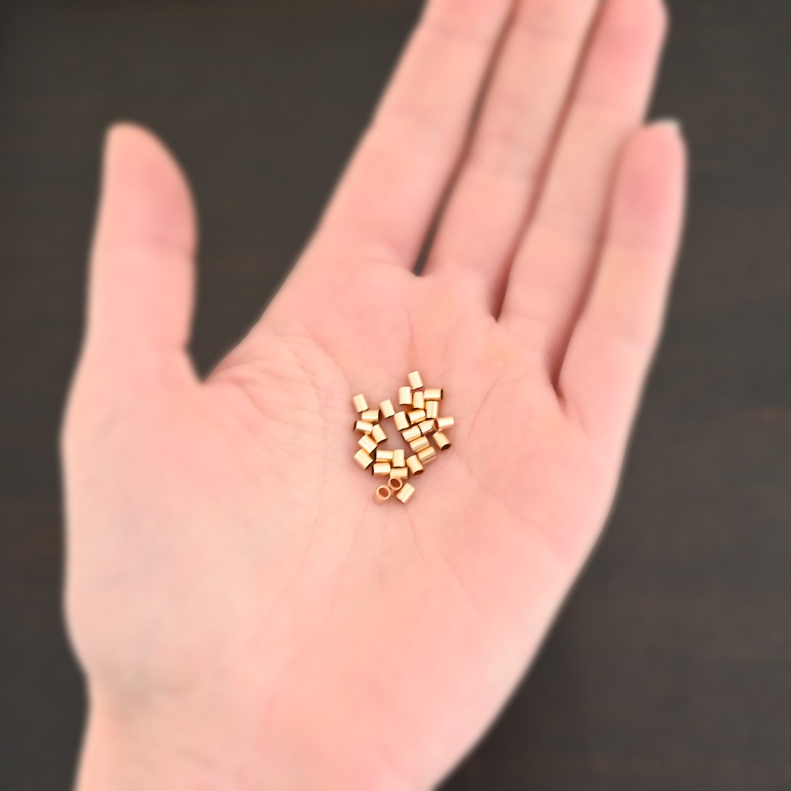 Gold Filled 3mm crimps shown in hand