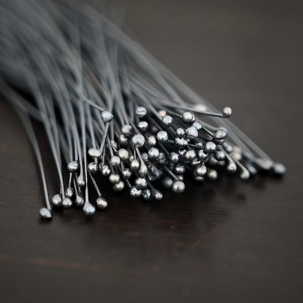 oxidized small ball headpins shown in dark background
