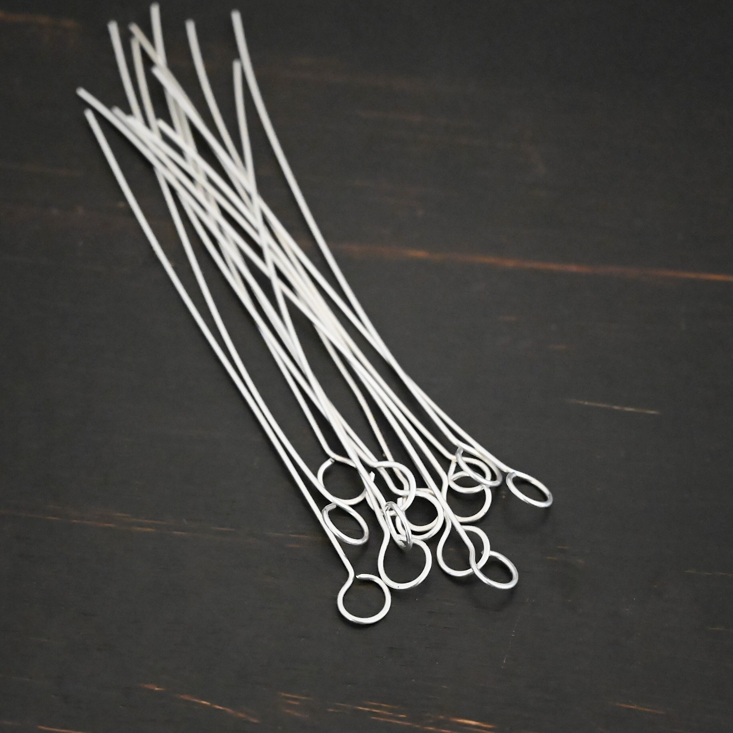 Silver shiny eye pins on dark background