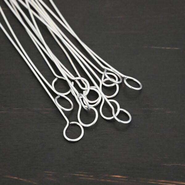 Silver shiny eye pins on dark background