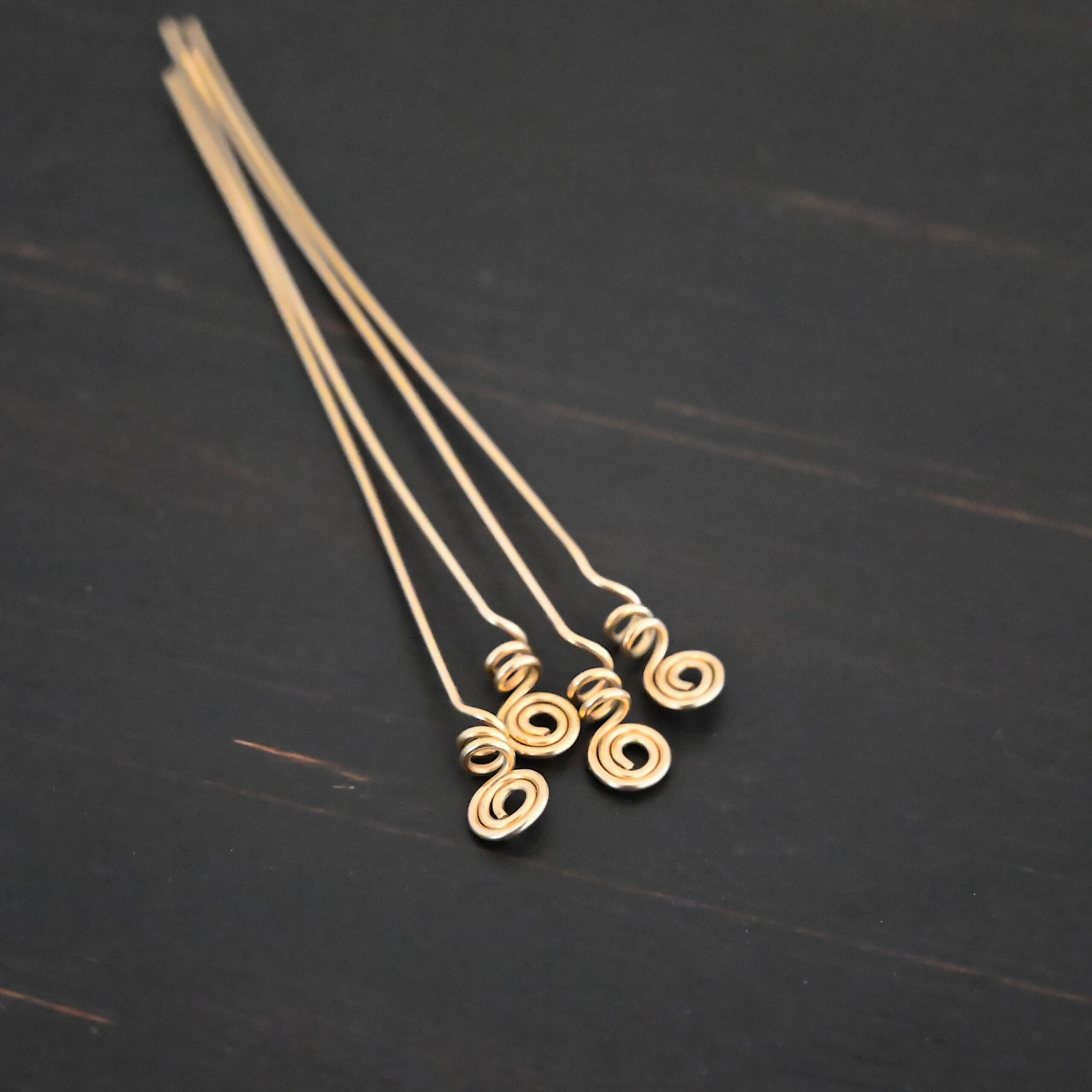 Gold Filled swirl headpin shown on dark background